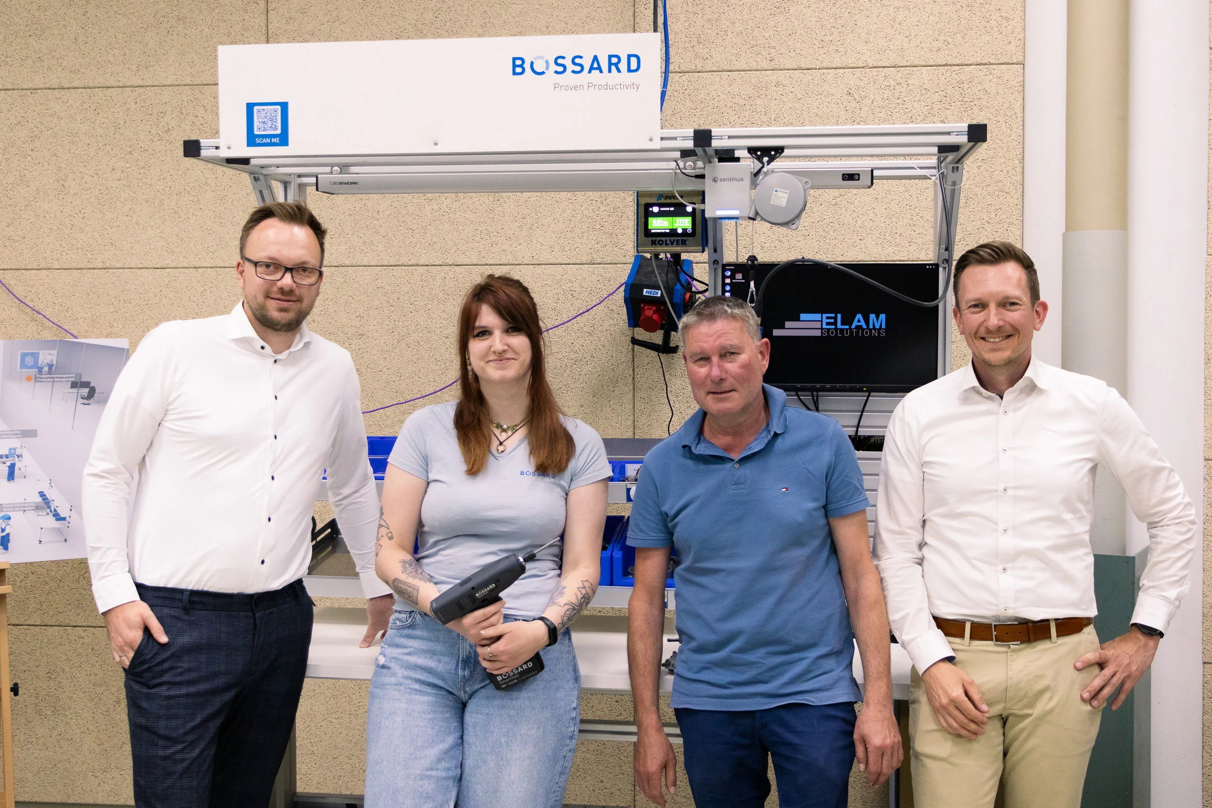 Making-of-Foto mit vier Bossard-Mitarbeitenden vor einem ELAM-Arbeitsplatz.