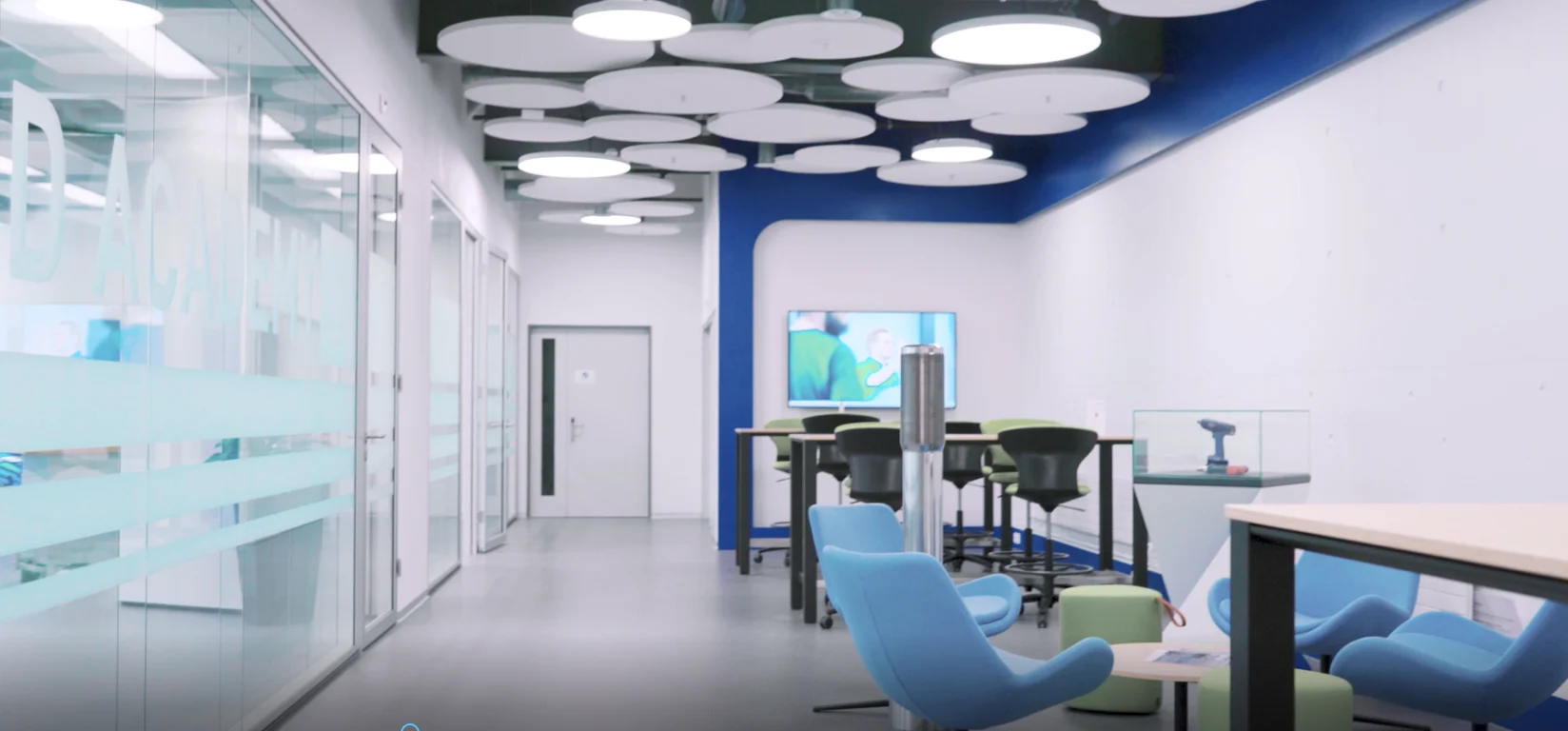 Ein Raum mit blauen Stühlen und Tischen, der eine einladende und moderne Atmosphäre ausstrahlt.