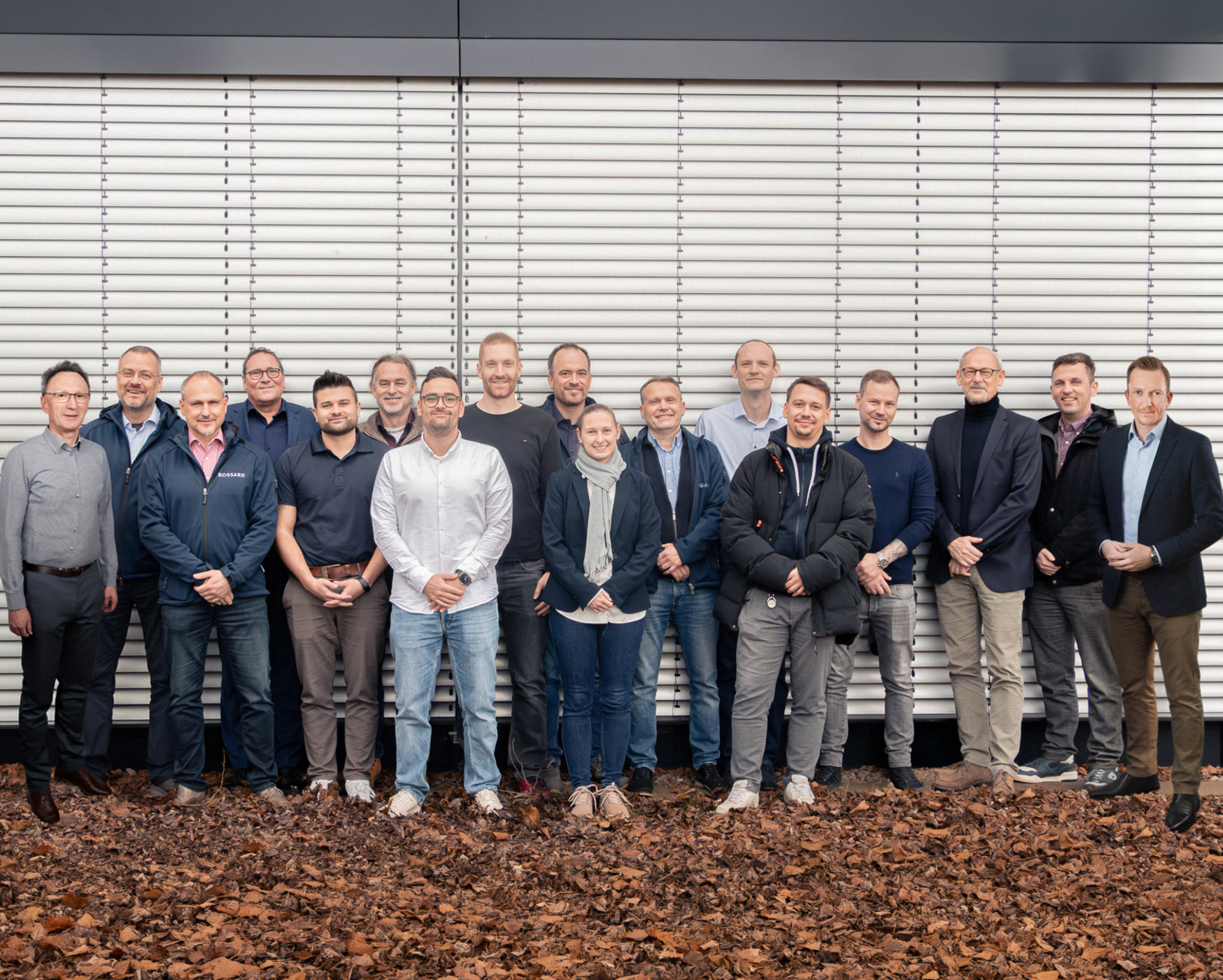 Gruppenfoto des Bossard TechDay-Expertenteams mit 16 Personen vor Fassade mit Lamellen.