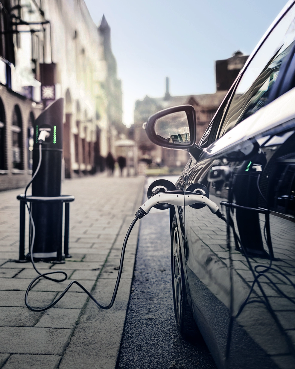 Elektroauto steht am Straßenrand und wird an einer Ladestation in der Stadt aufgeladen.