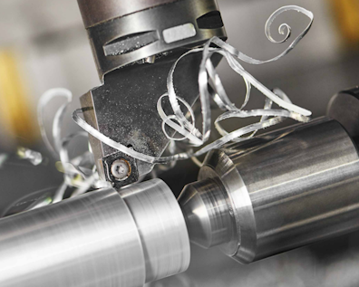 Nahaufnahme einer CNC-Drehmaschine mit Metallspänen beim Fräsen