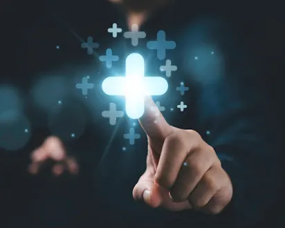 Hand berührt ein leuchtendes Plus-Symbol, umgeben von weiteren Pluszeichen auf dunklem Hintergrund