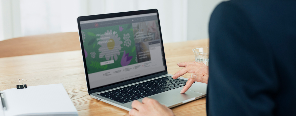Close-up of a woman on a laptop with Alko's ecommerce pages on the screen.