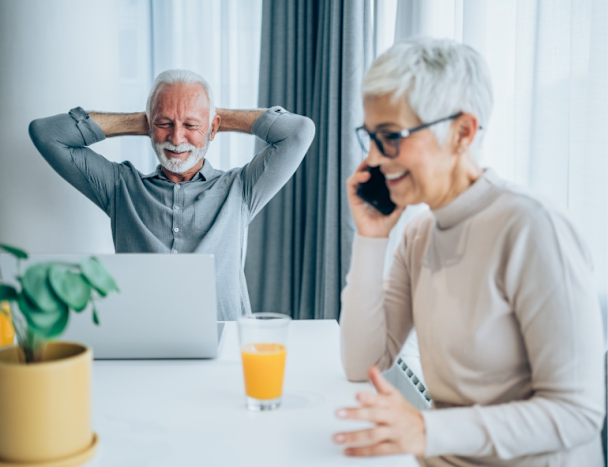 An older couple relaxing at home while one takes a call
