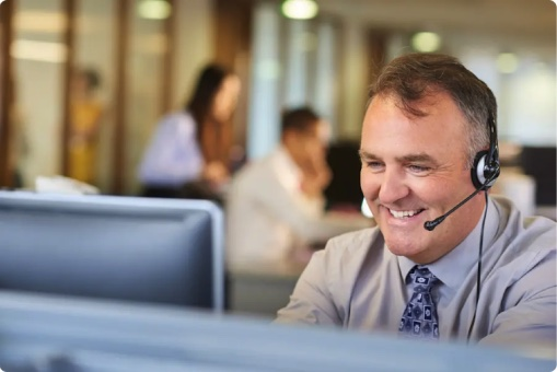 A TorFX currency expert on a headset at their desk