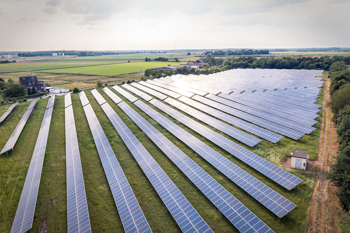 Ein Feld mit Reihen von Solaranlagen.