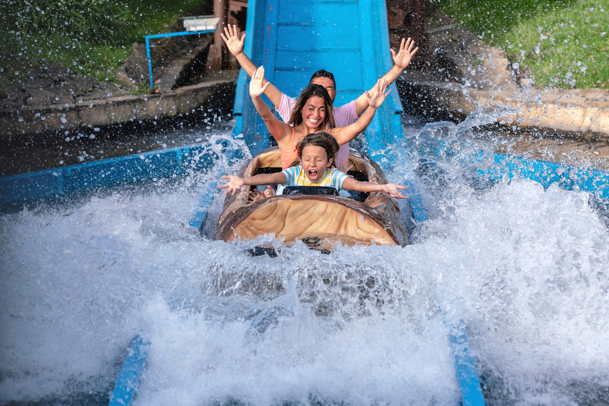 Mann und Frau mit einem Sohn auf einer Wildwasserbahn. 