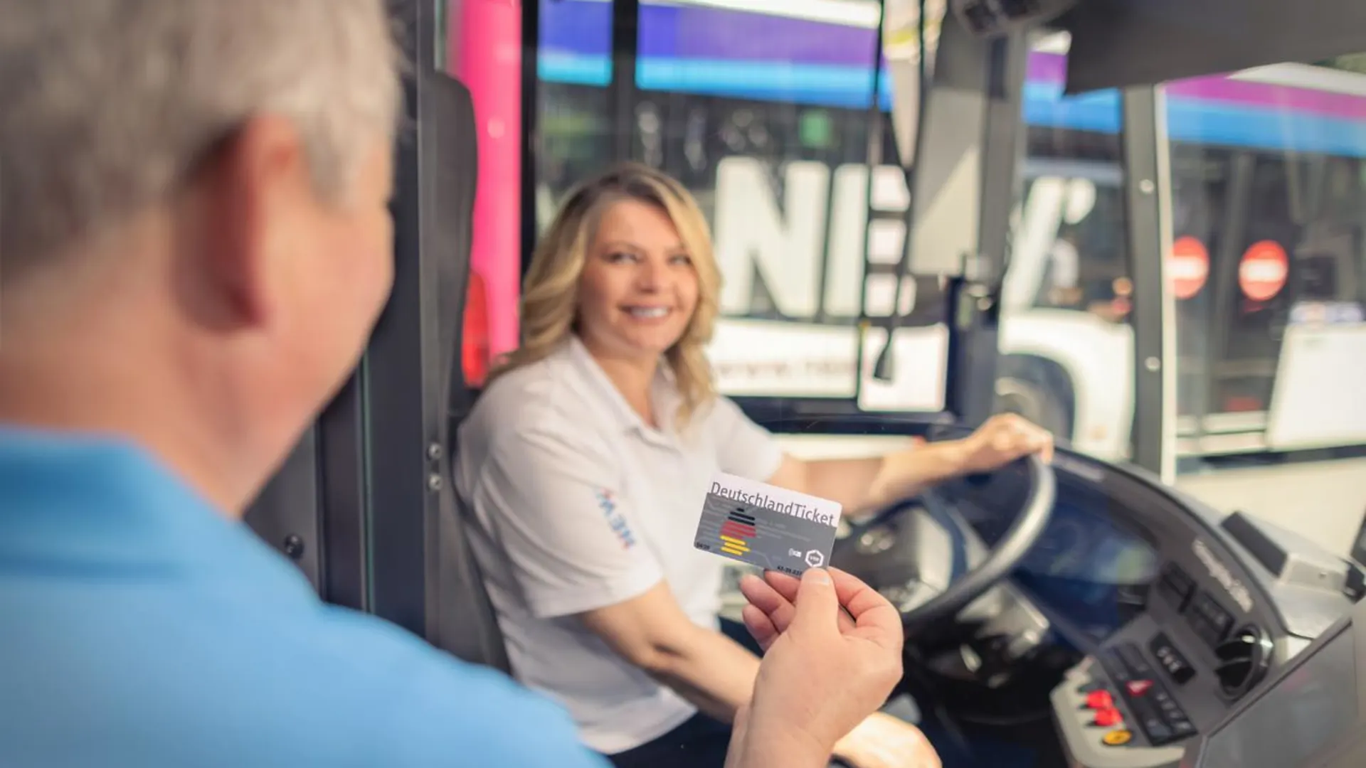 Fahrgast zeigt der Busfahrerin sein DeutschlandTicket Fahrgast zeigt der Busfahrerin sein DeutschlandTicket