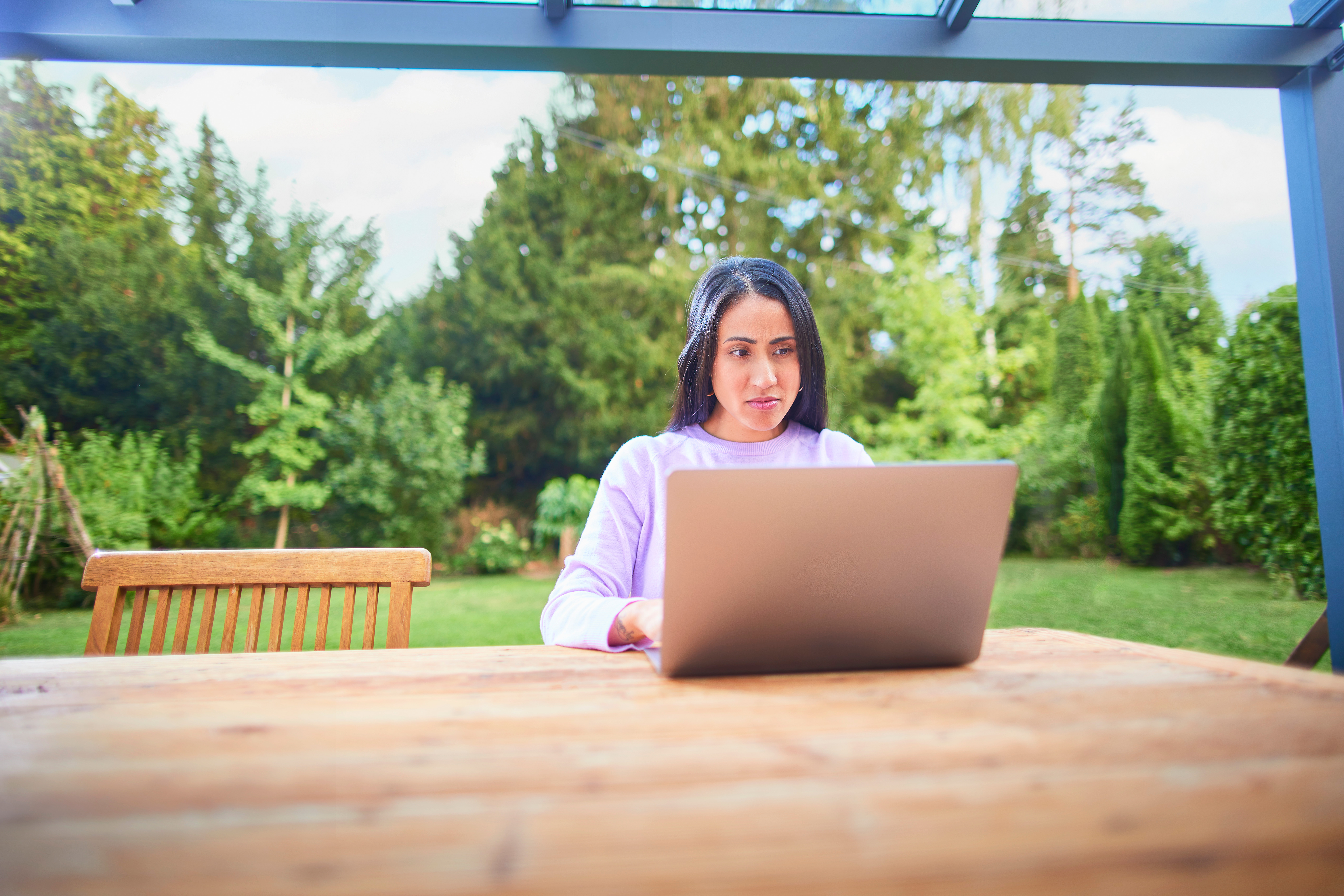 Eine Frau informiert sich am Laptop über schwankende Strom‑ und Gaspreise sowie über Einflussfaktoren des Energiemarkts, die sich auf die Kosten für Verbraucherinnen und Verbraucher auswirken.