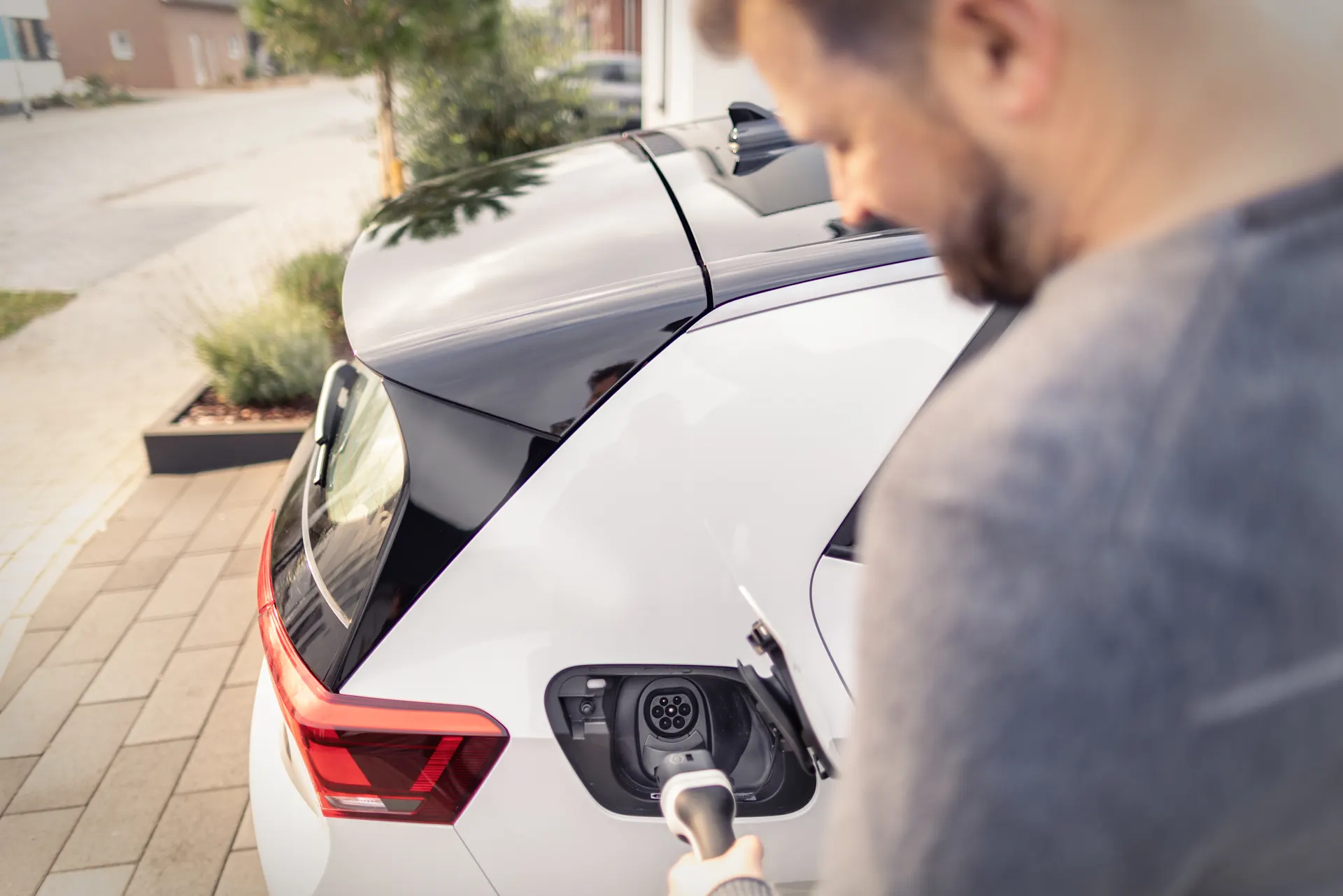 Ein Mann nutzt seine installierte Wallbox Ein Mann lädt sein Elektroauto mit seiner installierten Wallbox.