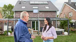 Kunde Installateur Einfamilienhaus Kunde und Installateur stehen vor einem Einfamilienhaus