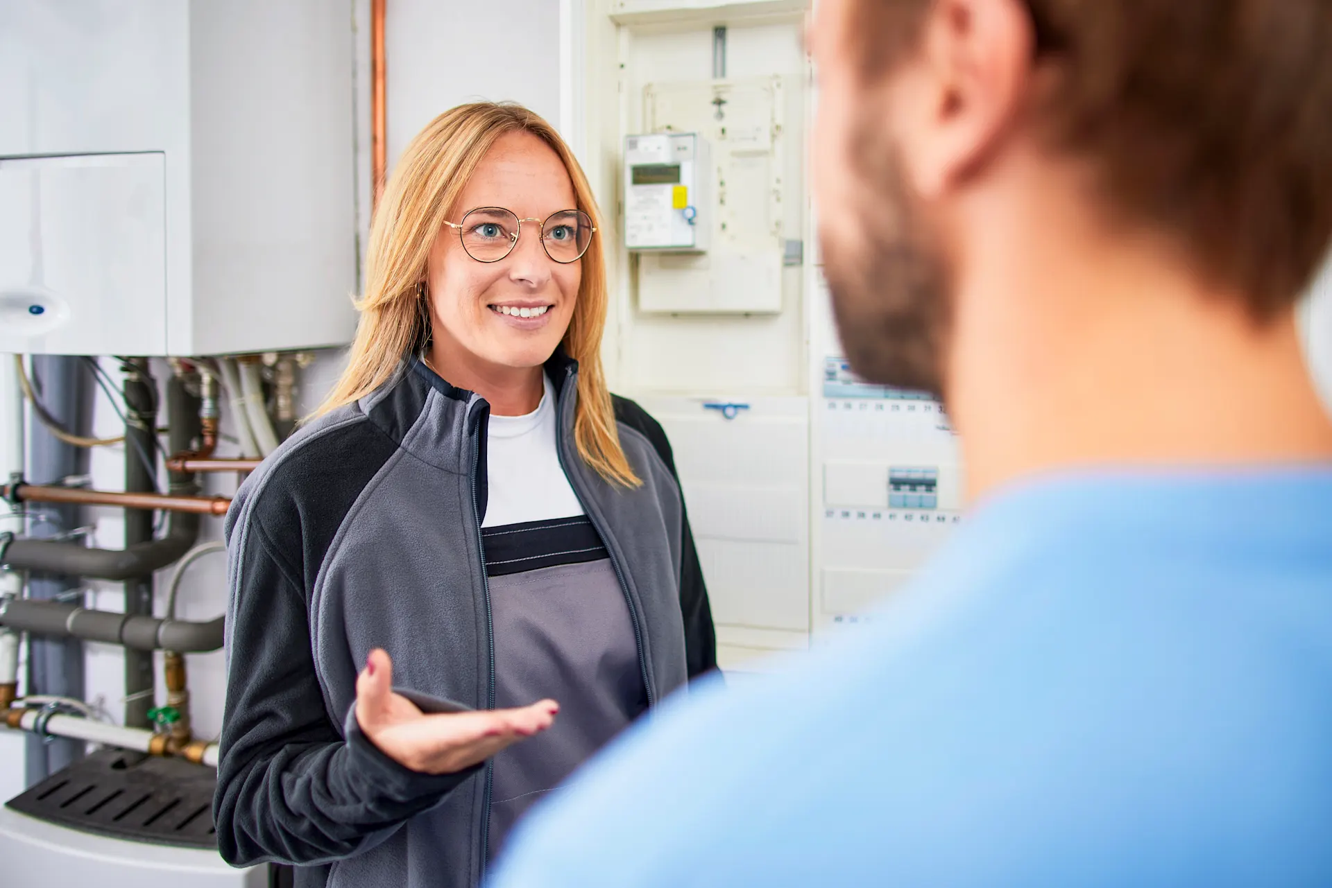 Installateurin berät über eine Wärmepumpe Installateurin berät einen Kunden über eine Wärmepumpe