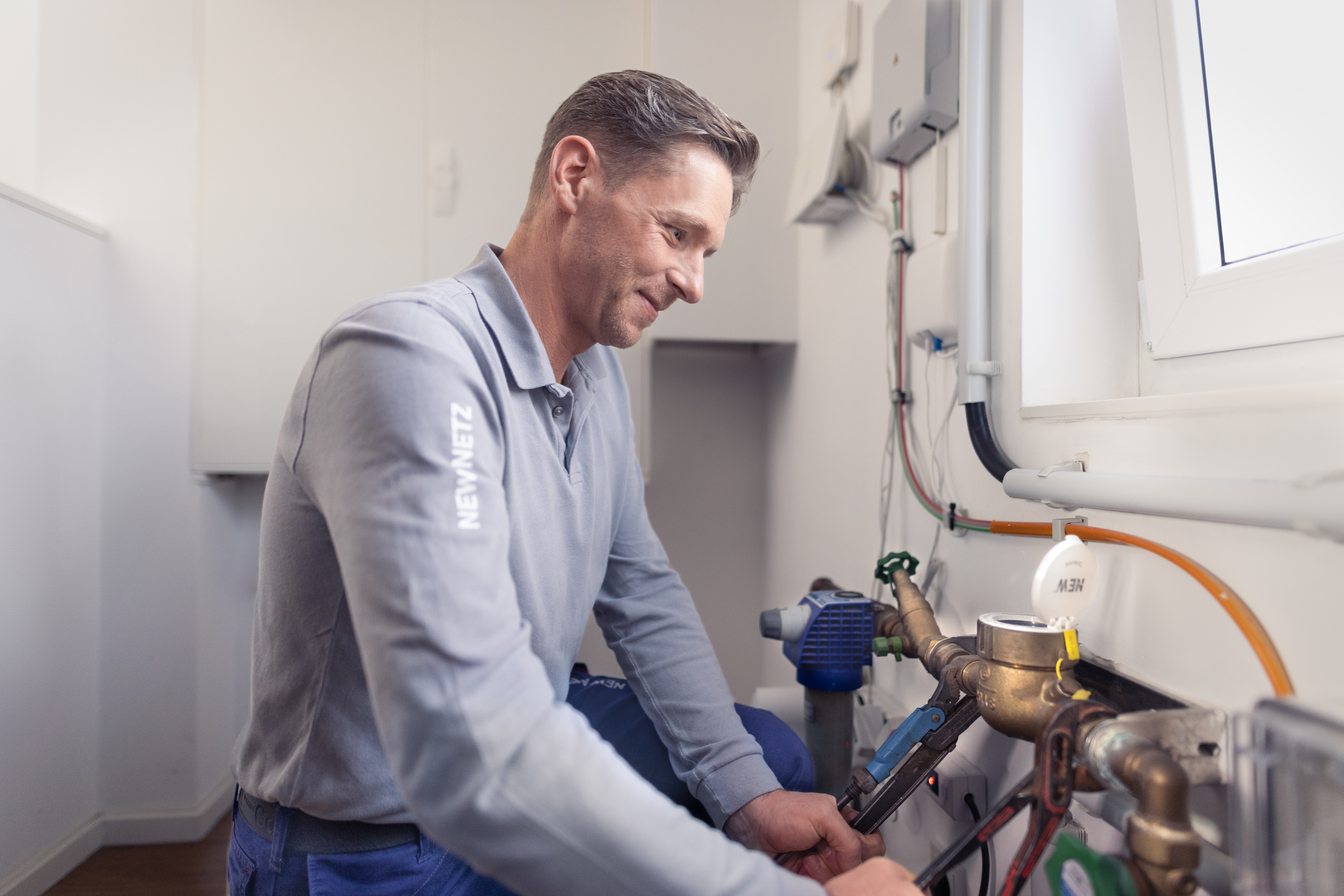 Ein Installateur arbeitete an der Wasseruhr und stellt die Wasserversorgung sicher 