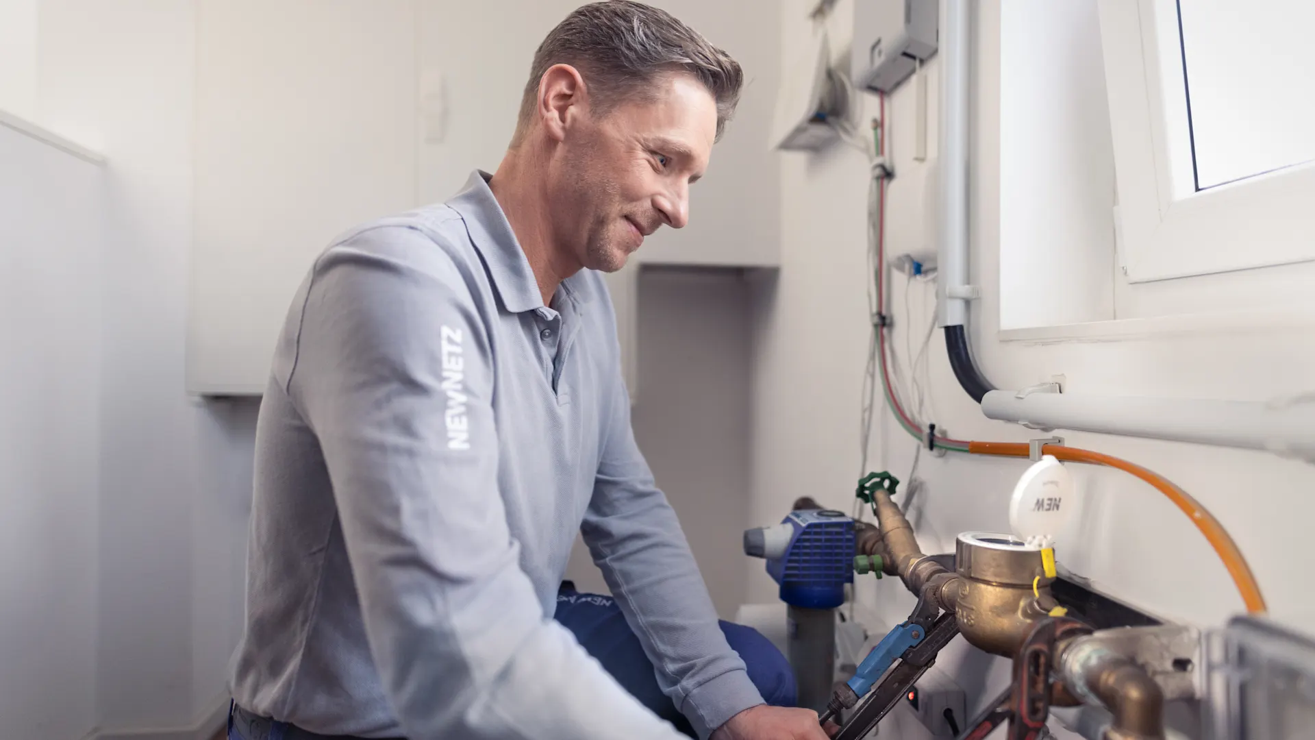 Installateur stellt die Wasserversorgung sicher Ein Installateur arbeitete an der Wasseruhr und stellt die Wasserversorgung sicher