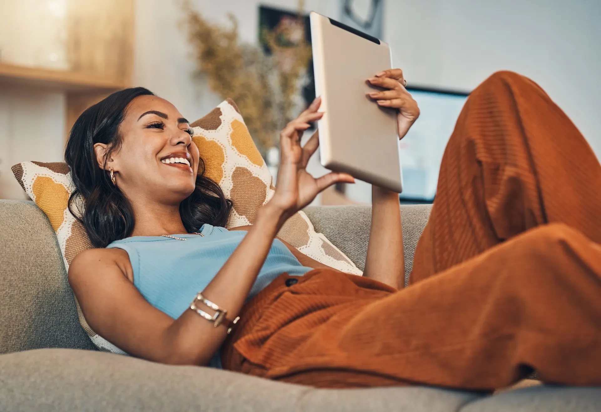Junge-Frau-liegt-auf-dem-Wohnzimmer-mit-Tablet Junge Frau liegt auf dem Sofa mit Tablet.