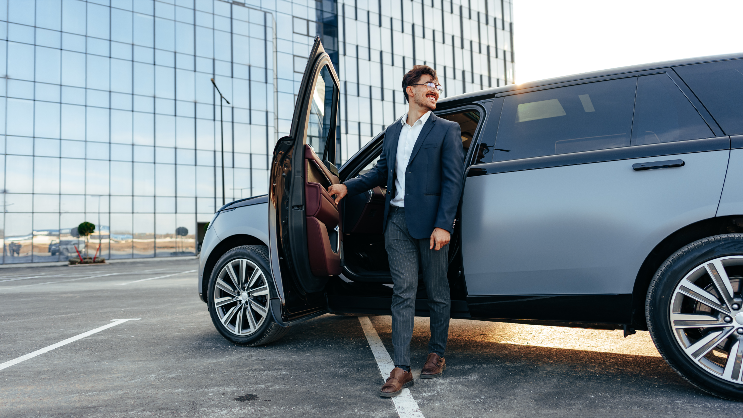 Ein Mann steigt aus einem silbernen SUV