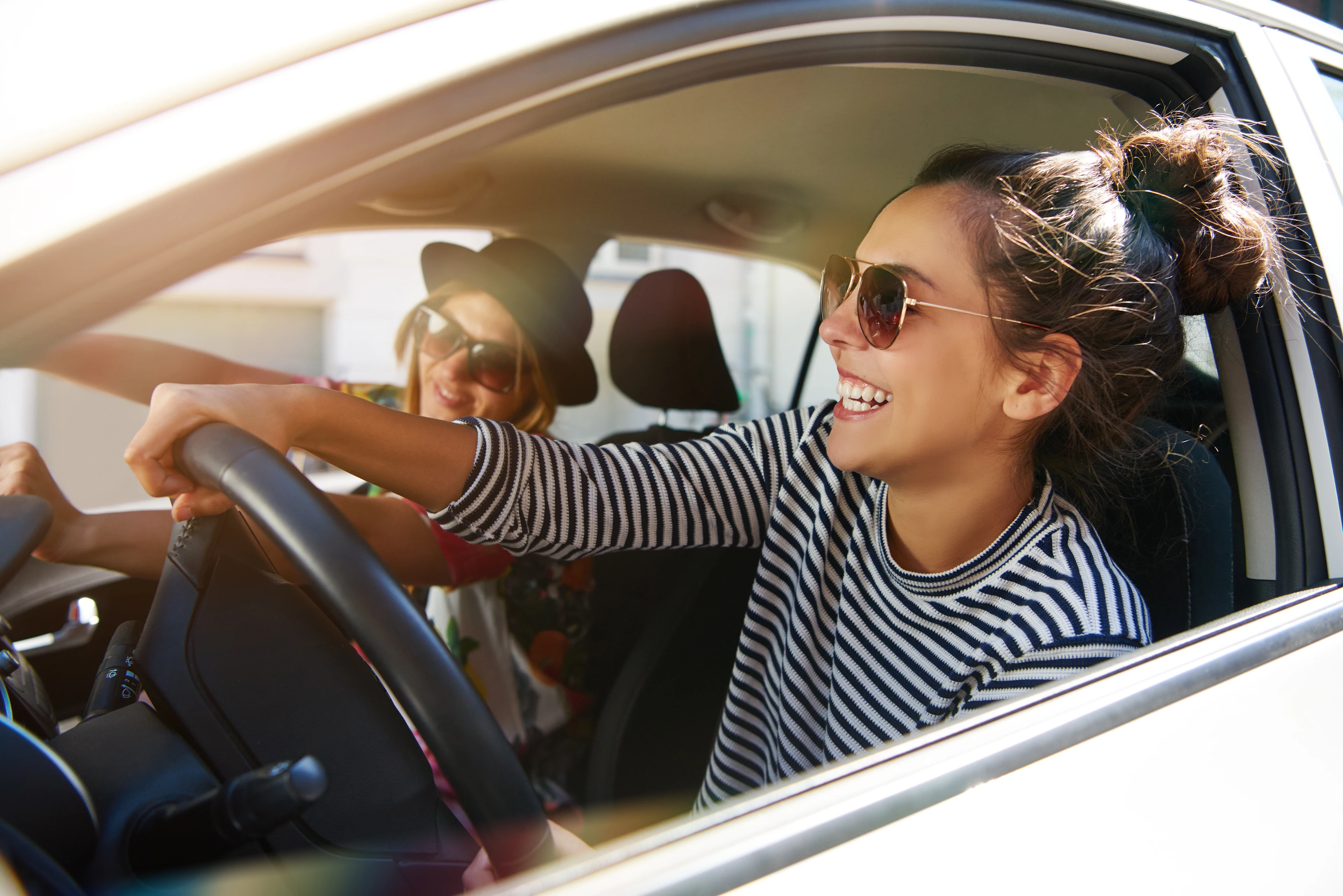 Zwei Frauen fahren glücklich in ihrem Auto