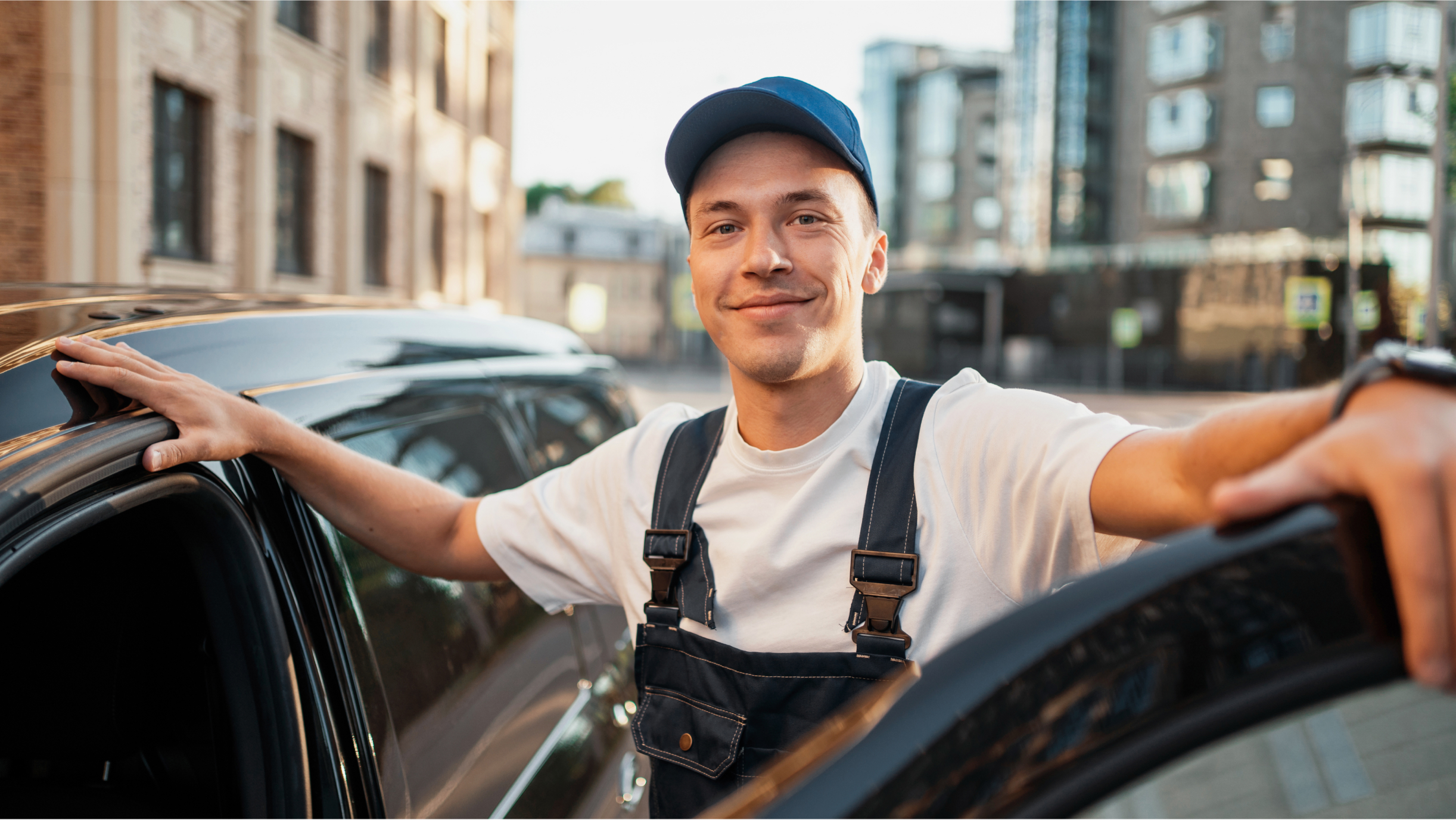 Ein Mann in Service-Uniform steht mit dem geöffneten Auto