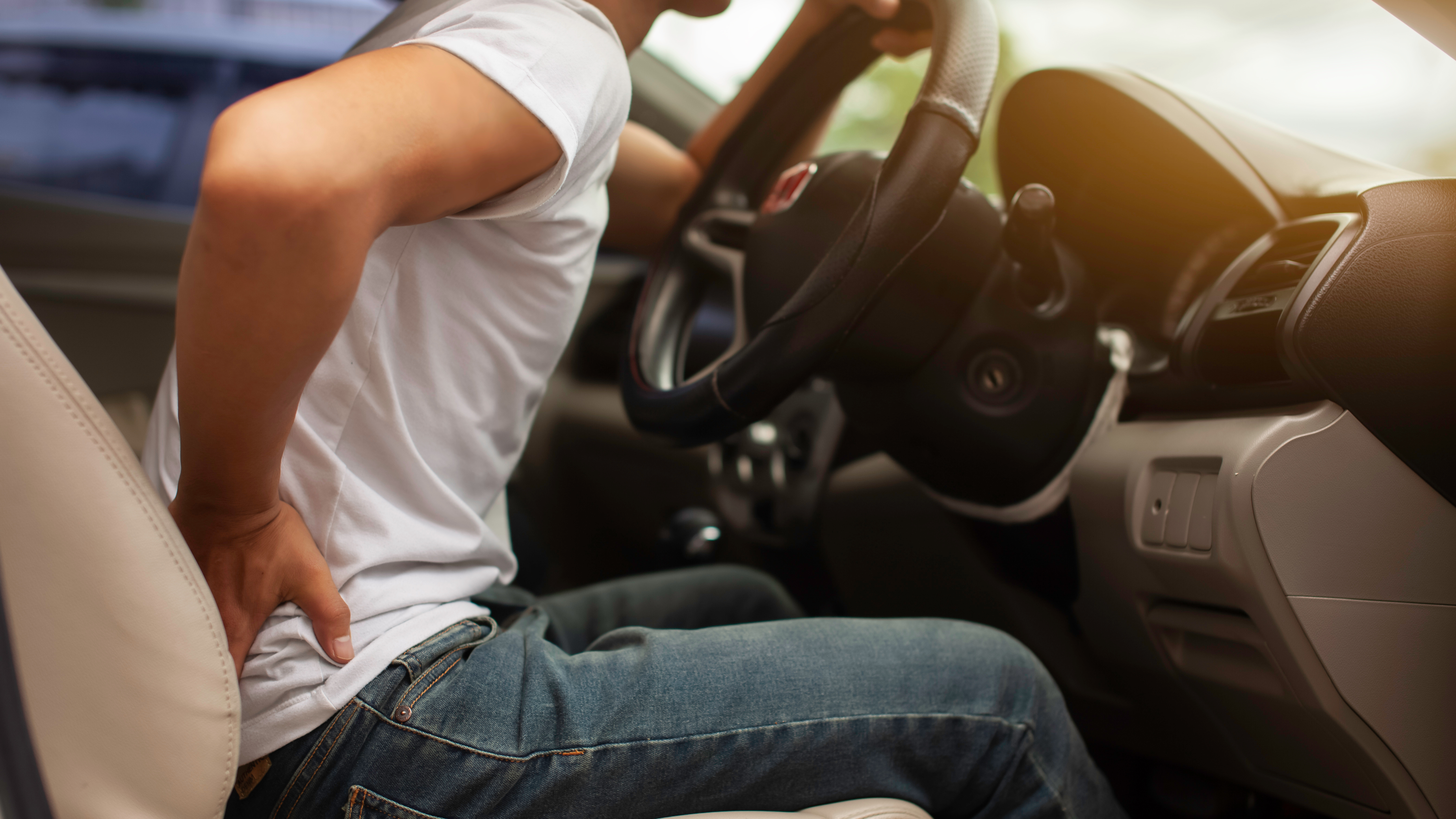 Autofahrer stützt seinen Rücken mit der Hand