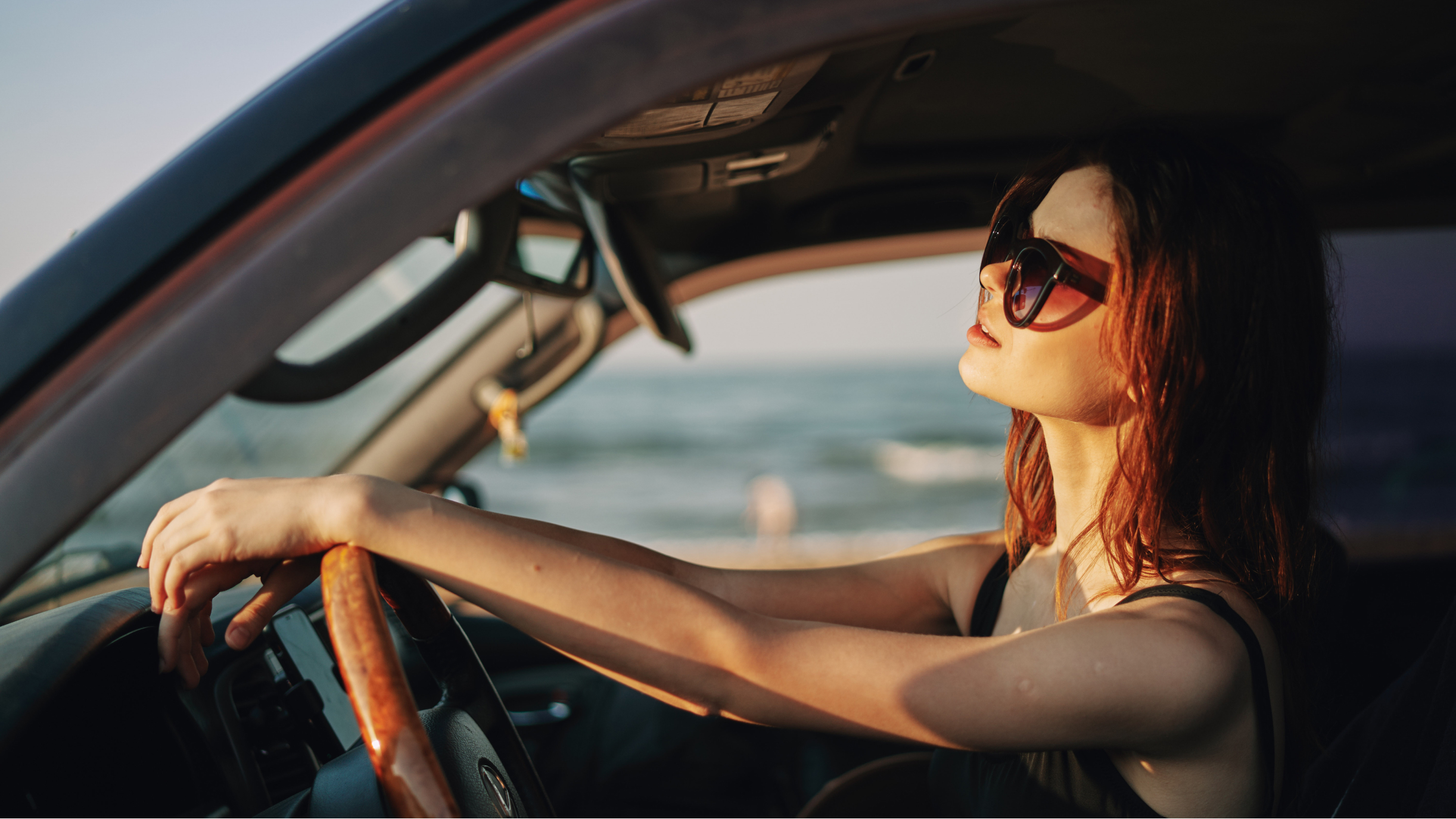 Frau mit Sonnenbrille im Auto