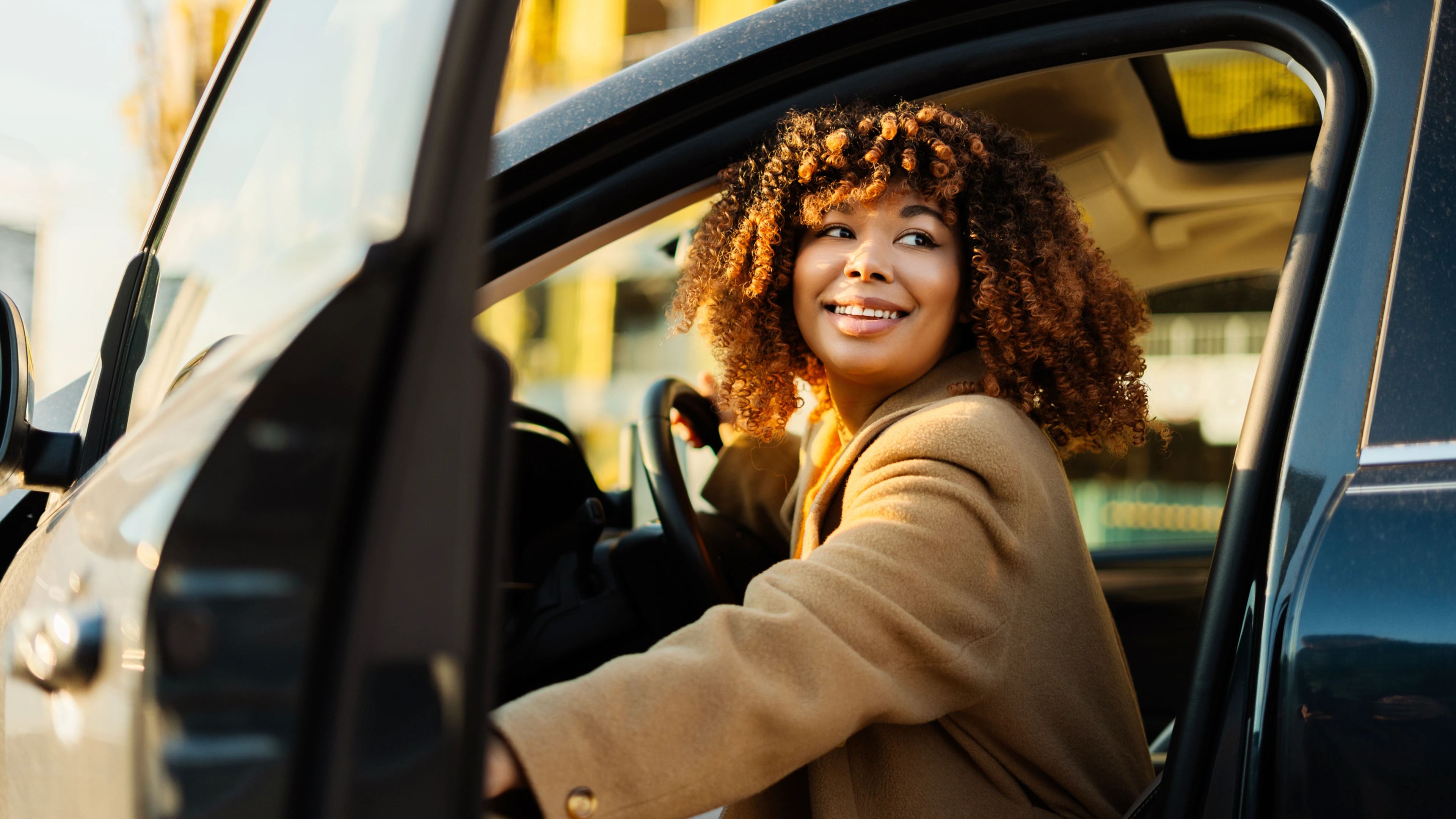 Eine Frau schaut aus geöffneter Autotür