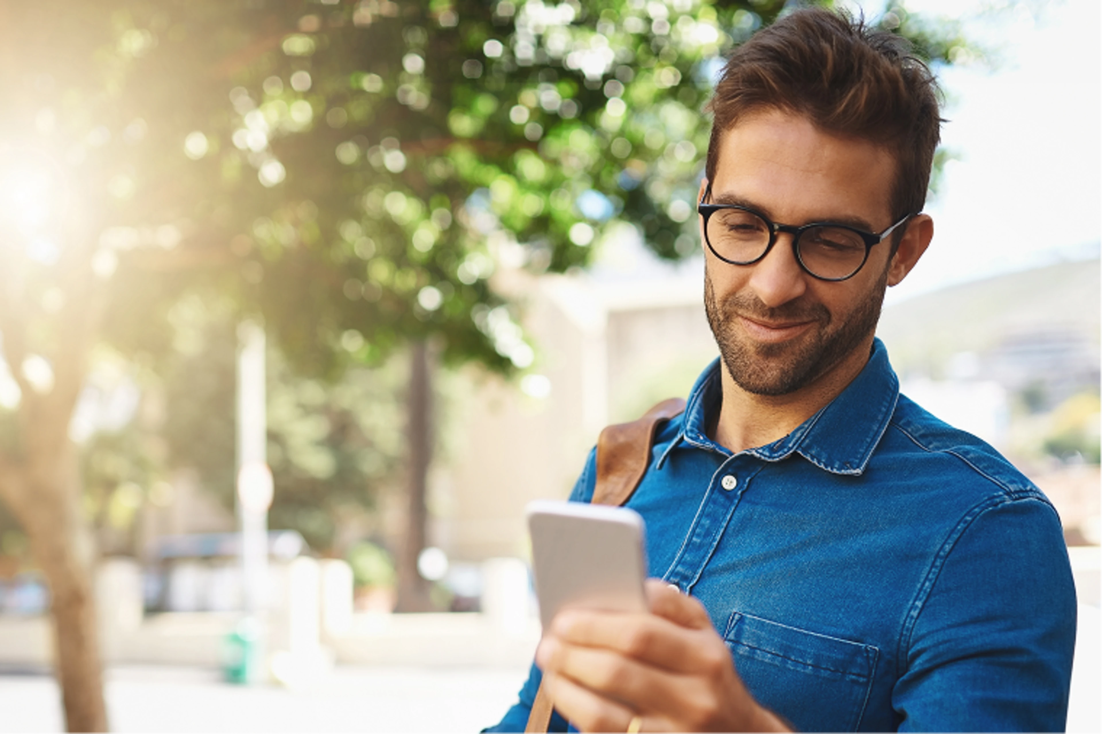 Mann hält Handy in der Hand und schaut darauf.