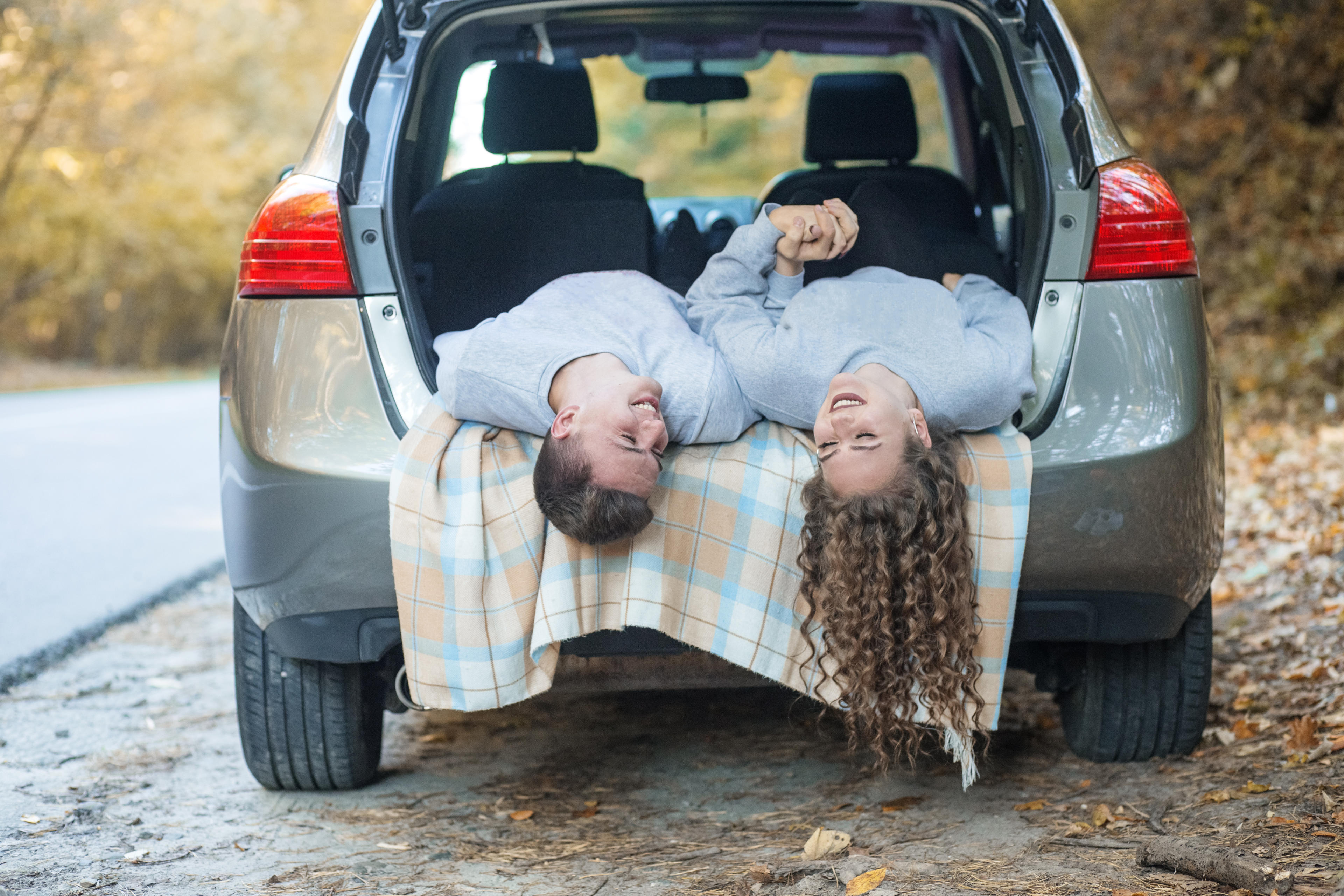 Ein paar liegt im Kofferraum im geöffneten Auto