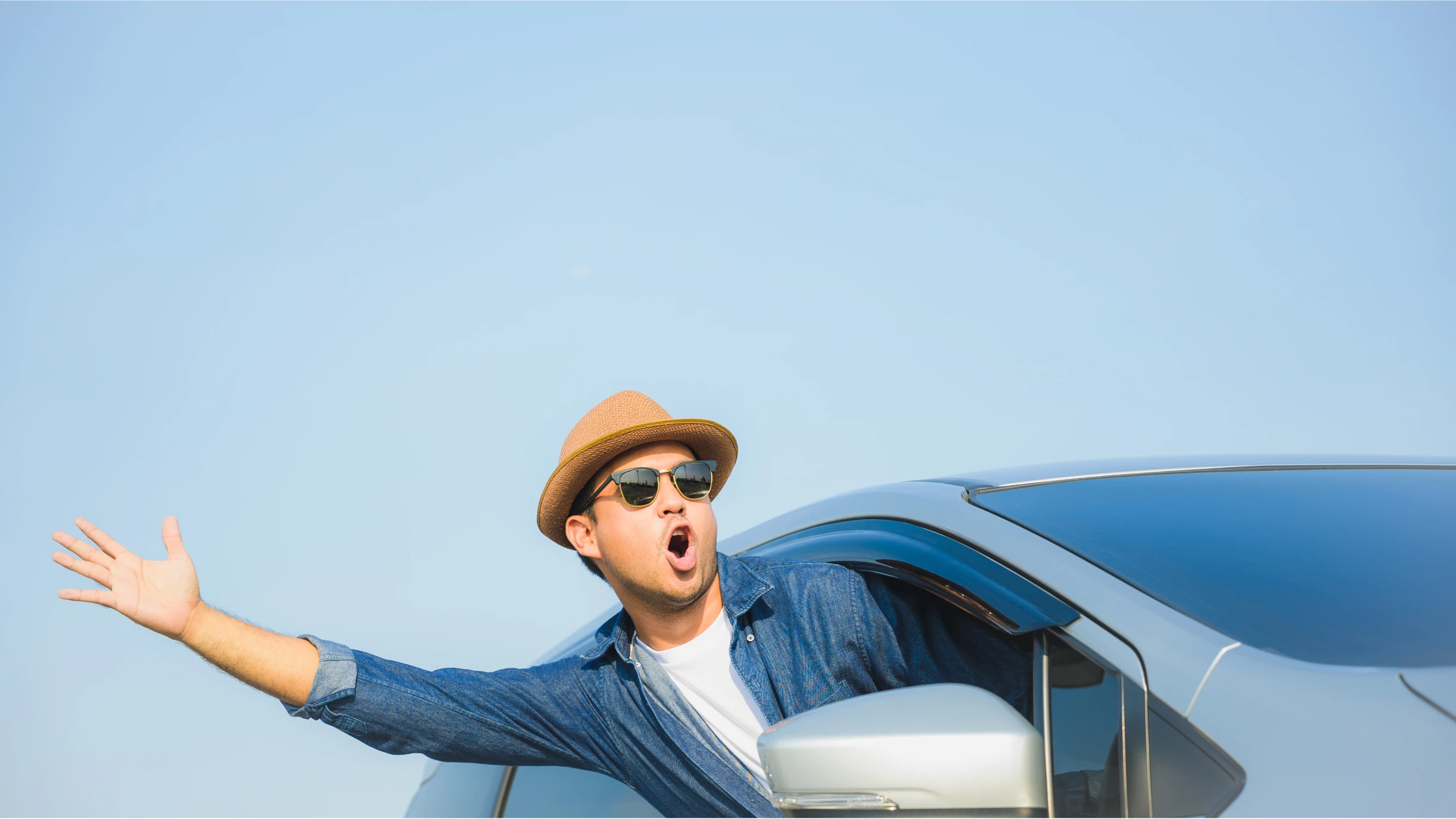 Mann winkt aus einem Auto