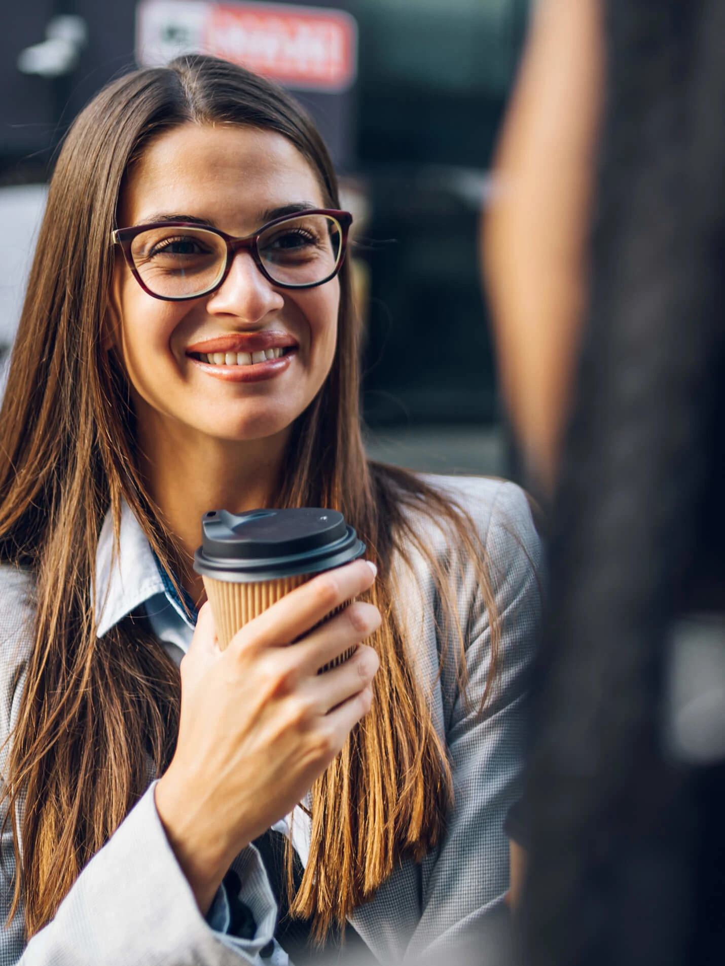 Frau lachend mit Kaffeebecher in der Hand