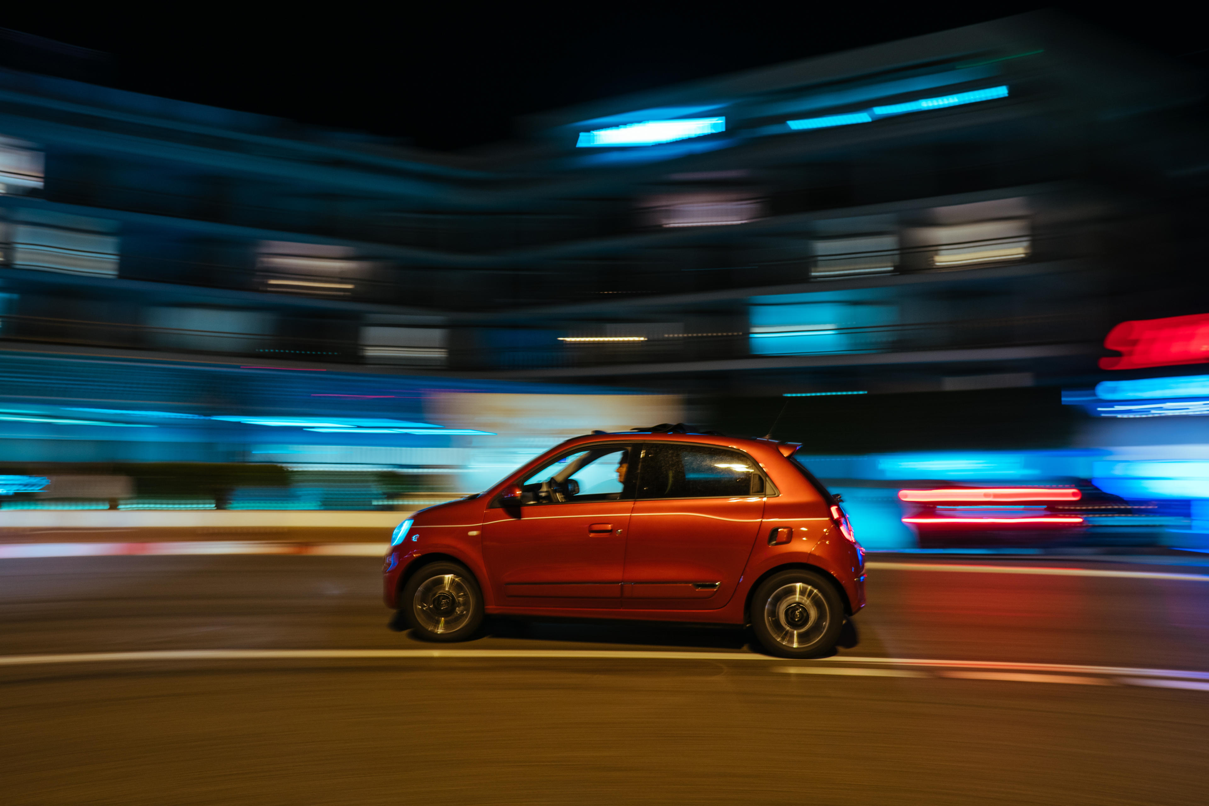 Fiat 500 flitzt im Licht der Straße durch die Nacht