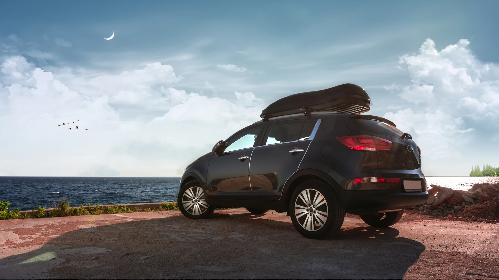 SUV mit Dachbox am Meer