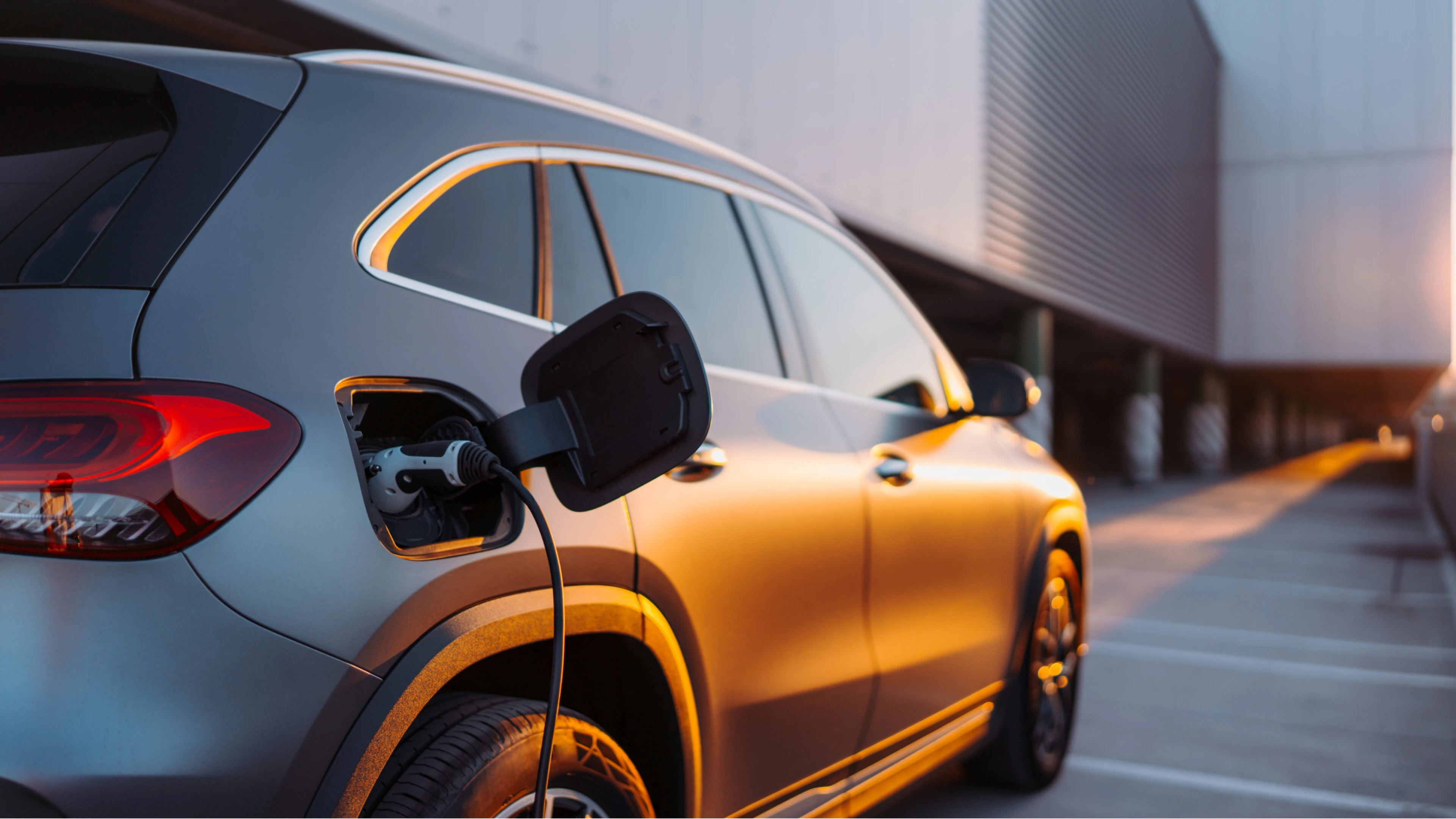 Elektroauto wird vor einem Gebäude geladen