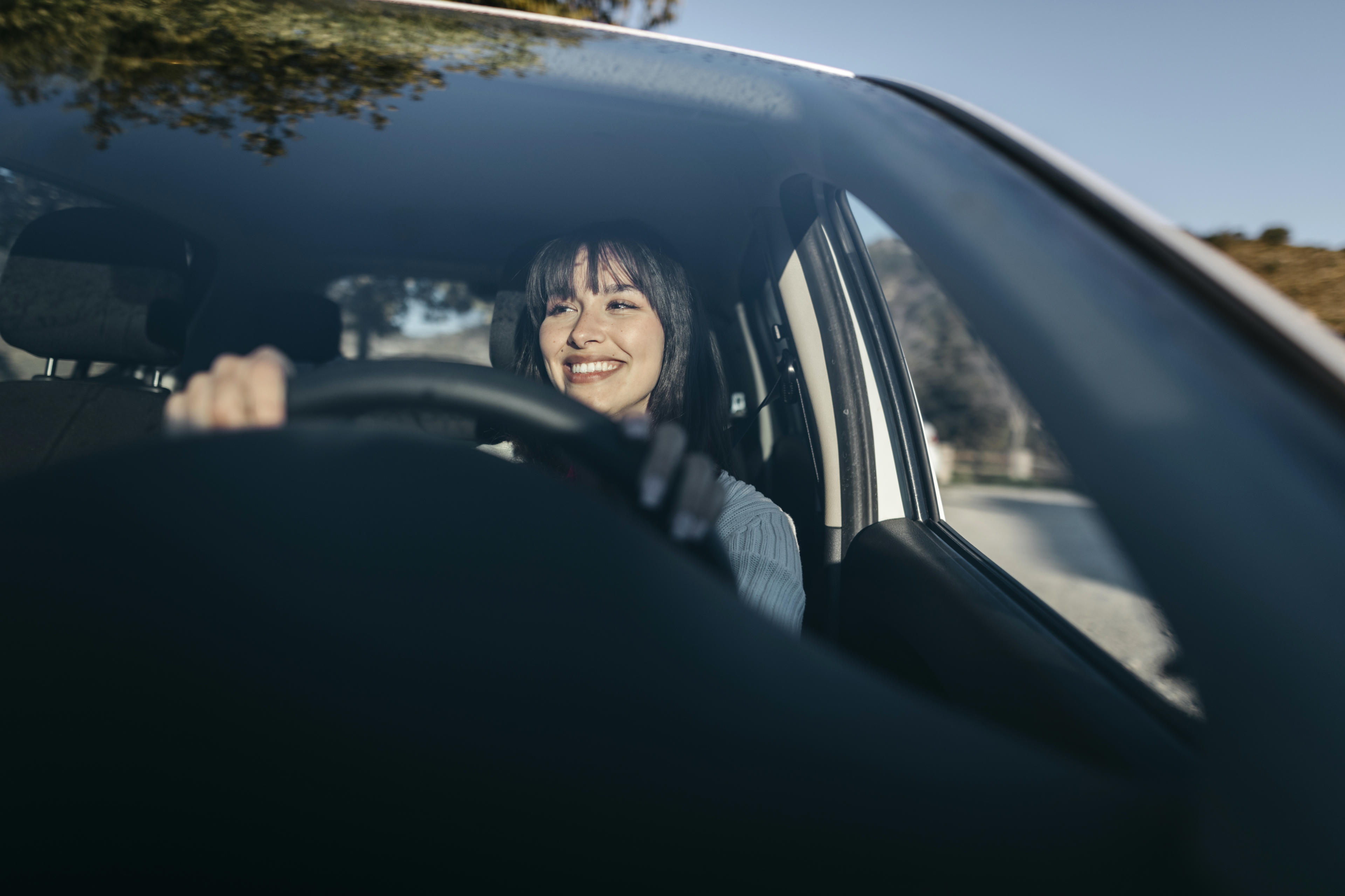 Autoverkäufer präsentiert einer Frau einen Neuwagen