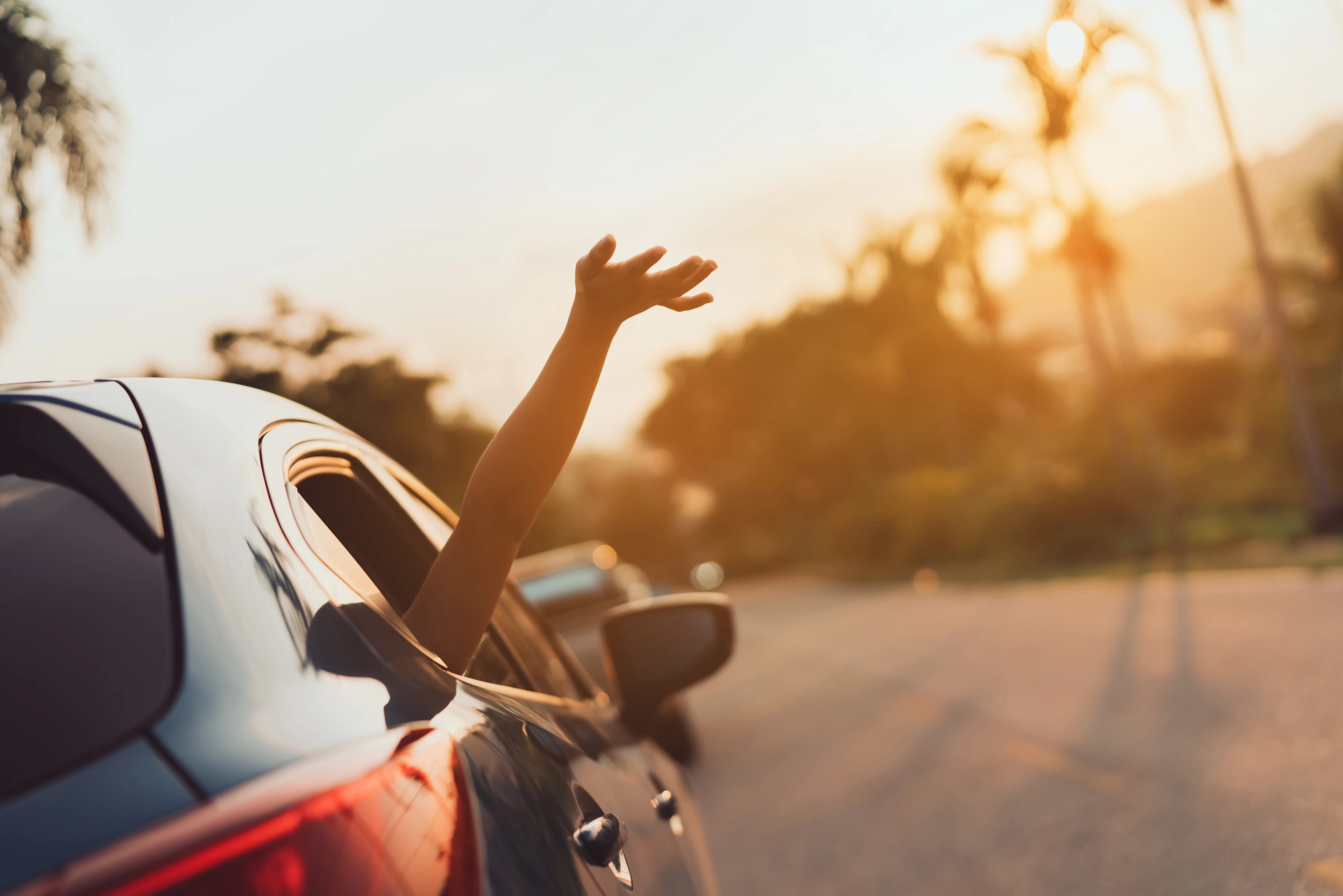 Aus einem fahrenden Auto wird ein Arm gestreckt