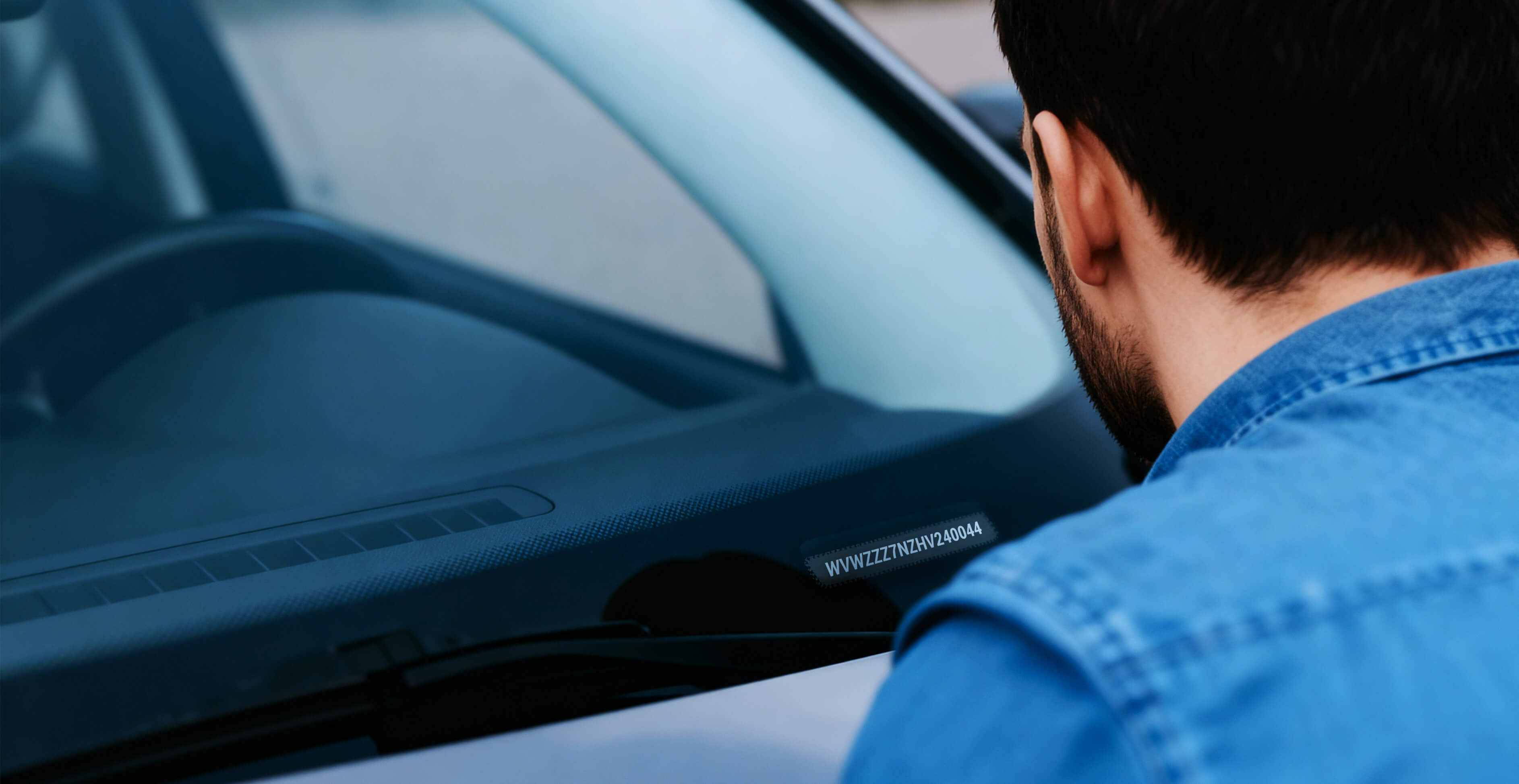 Mann liest FIN Nummer von seinem Auto ab