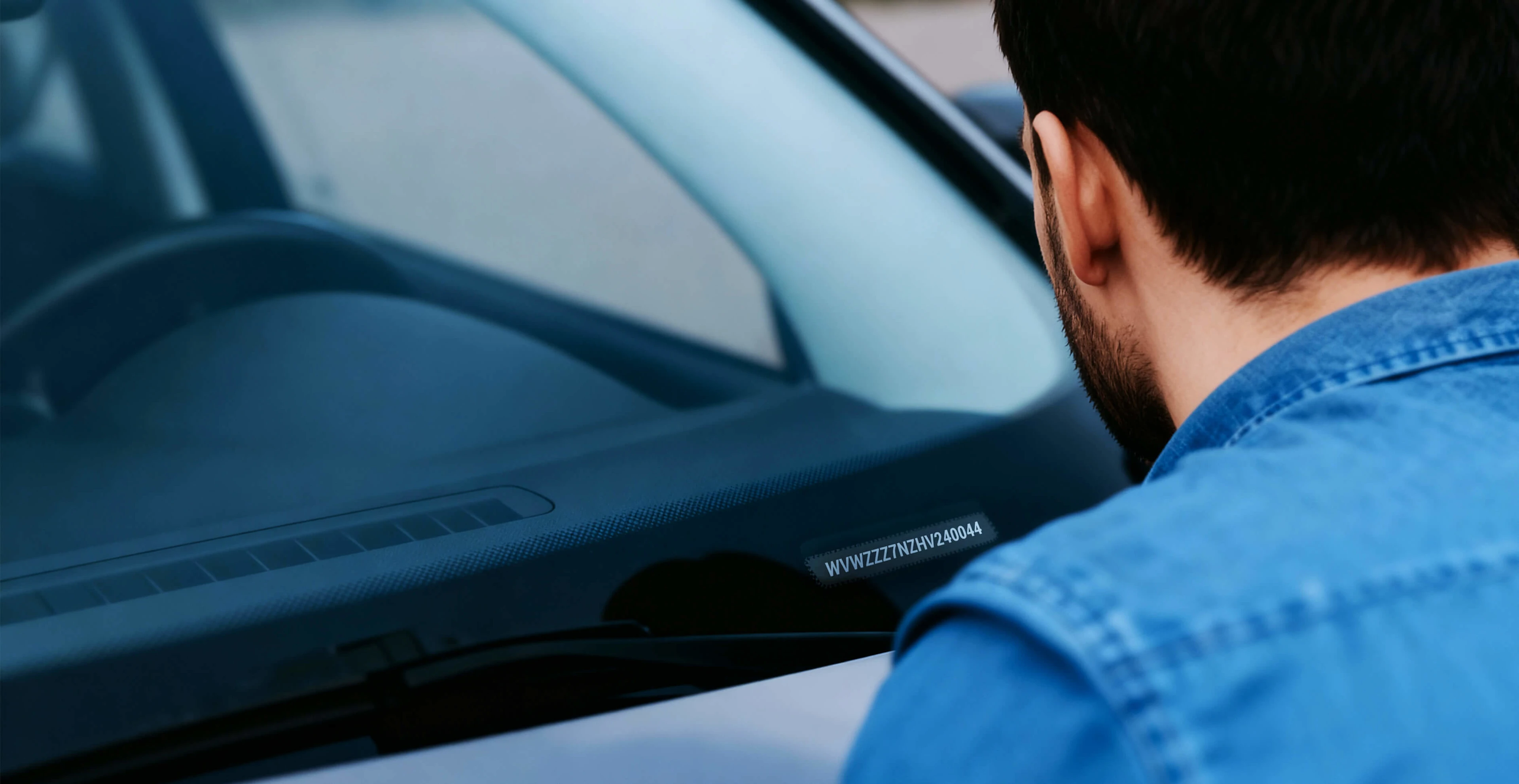 Mann liest FIN Nummer von seinem Auto ab