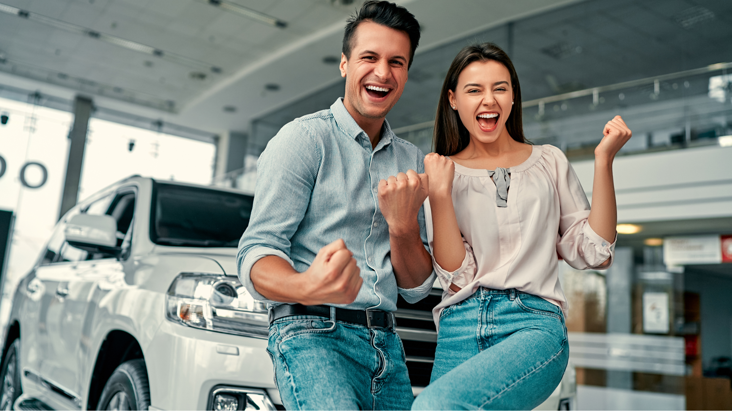 Paar steht vor einem Auto und freut sich
