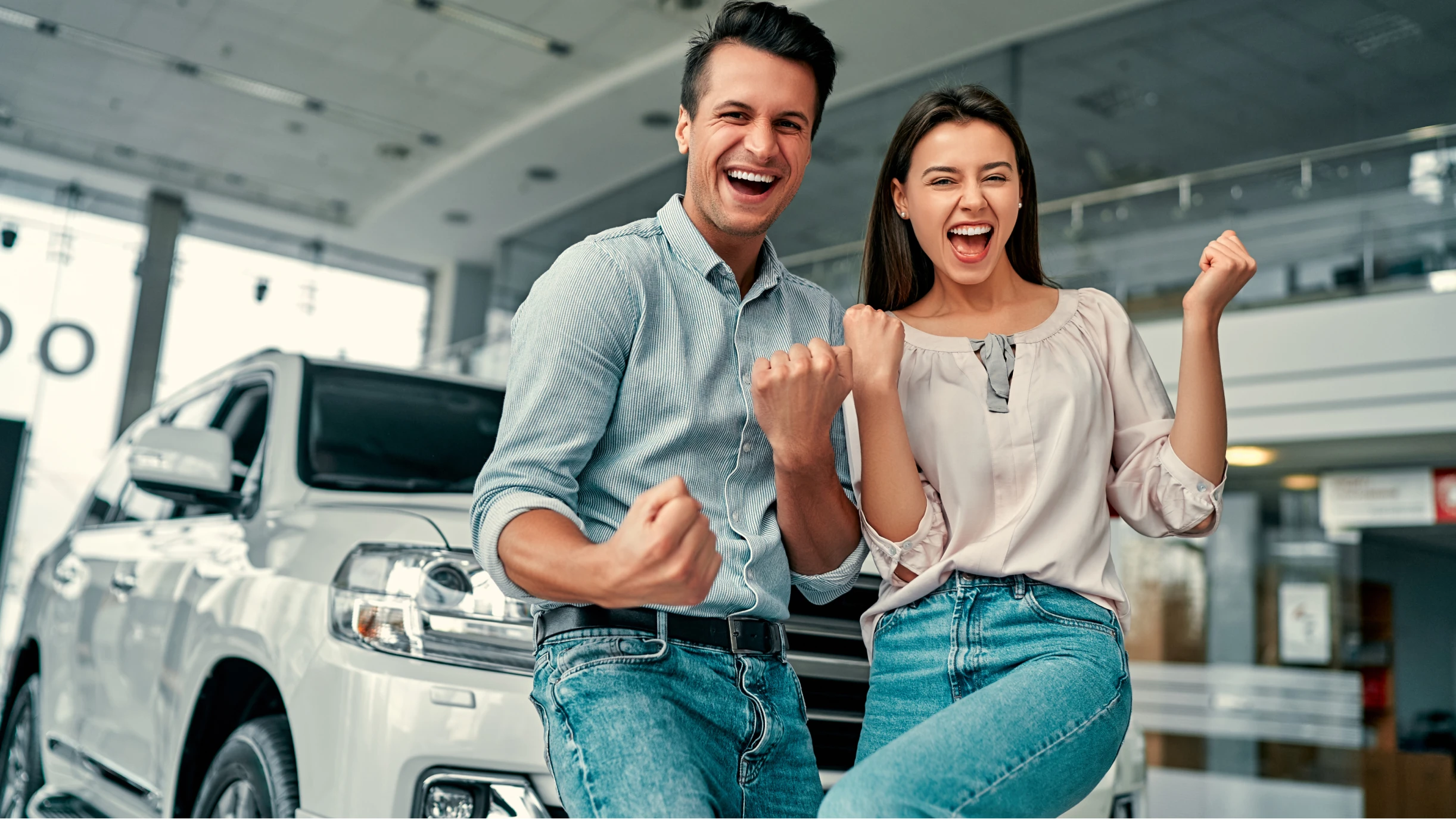 Paar steht vor einem Auto und freut sich