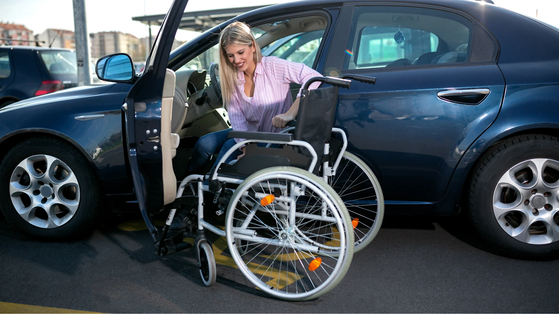 Frau mit Rollstuhl am Auto