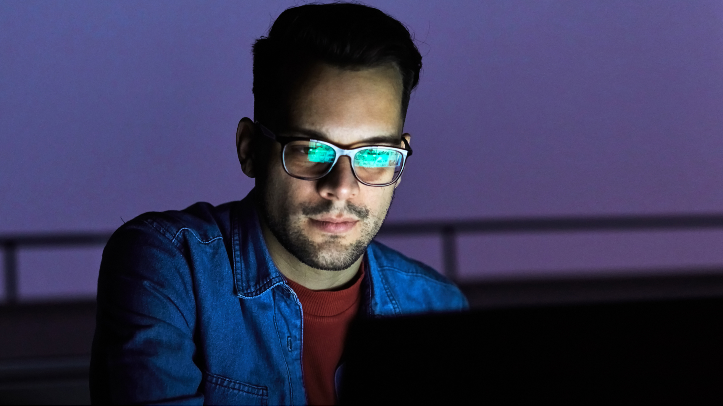 Mann am Laptop mit lila Nachthimmel