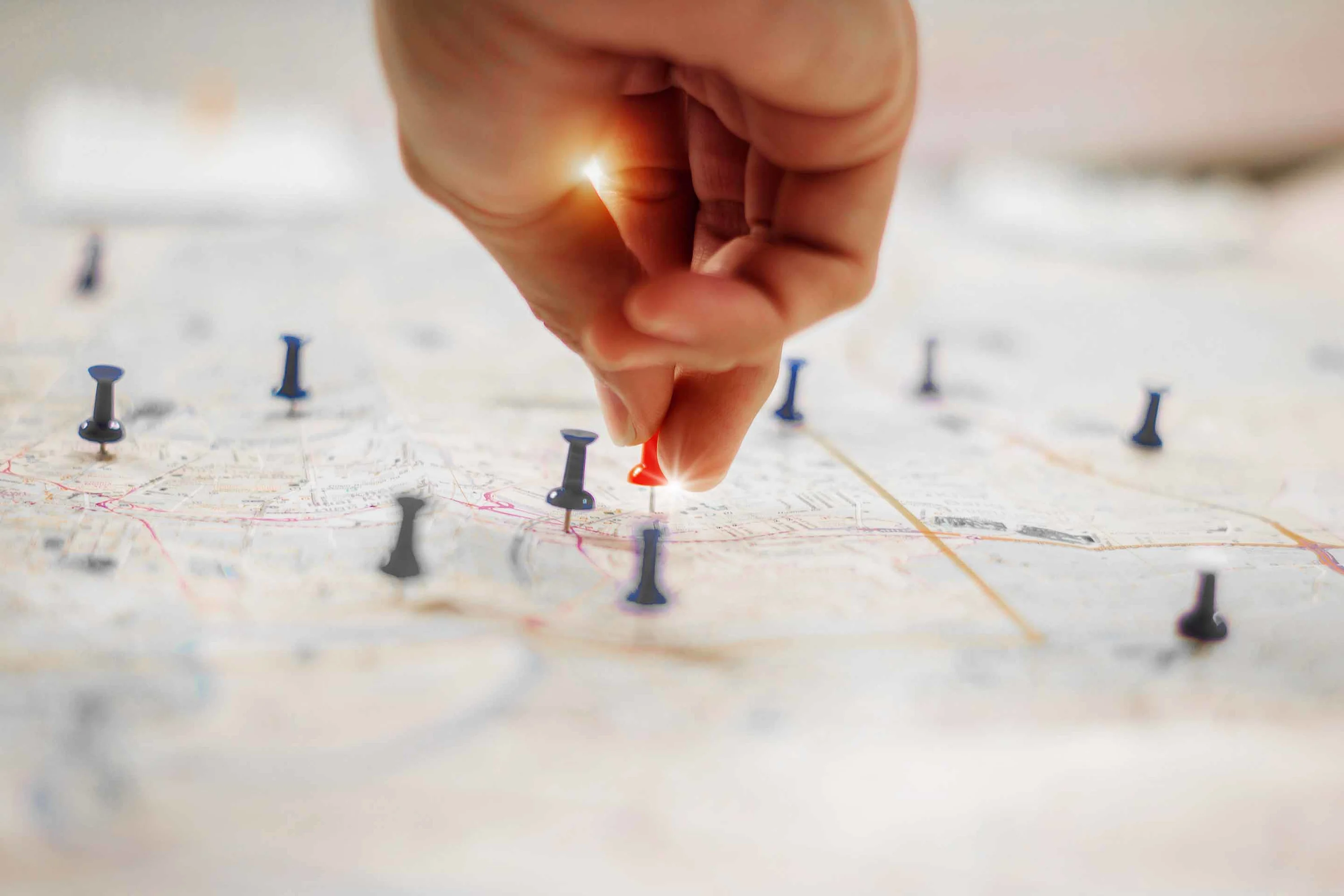 map with pins Image: A hand putting pins in a map. Land purchasing benefits