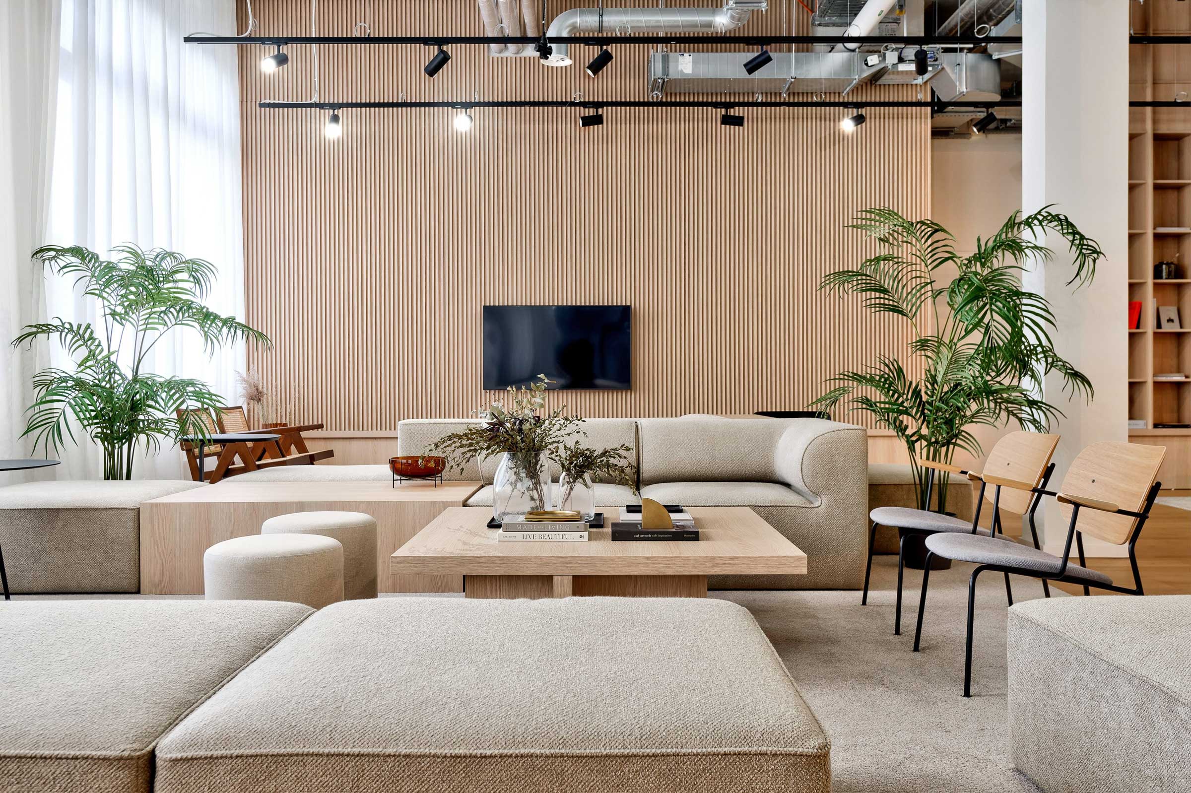 Zeigt Lobby von Habyt mit naturfarbenen, modernen Moebeln und hellem Holz