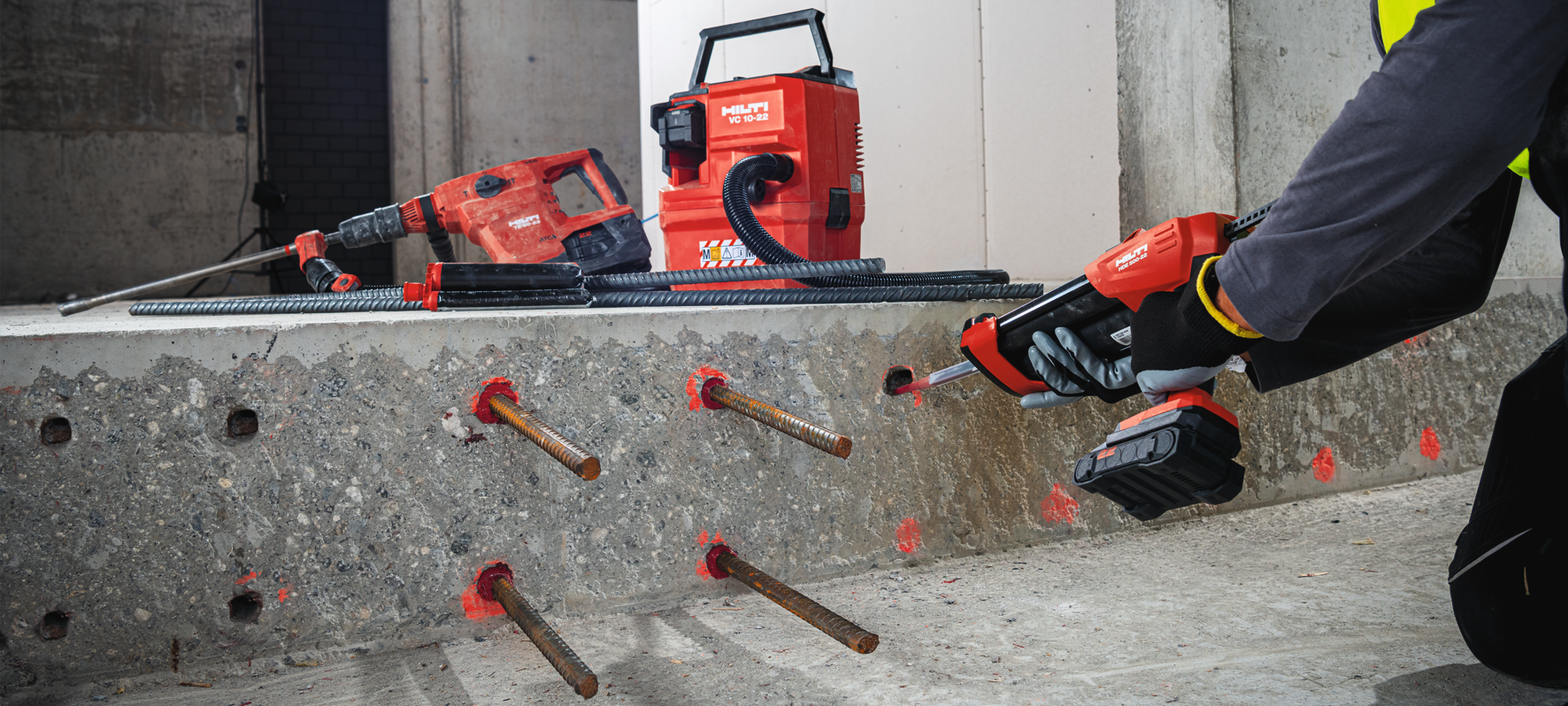 Jobsite worker injecting RE 500 with cordless dispenser HDE 500-22 into concrete for rebar installation