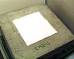 Concrete slab with a white square patch centered on the surface; handwritten text “LP4013” is visible on the front edge of the slab.