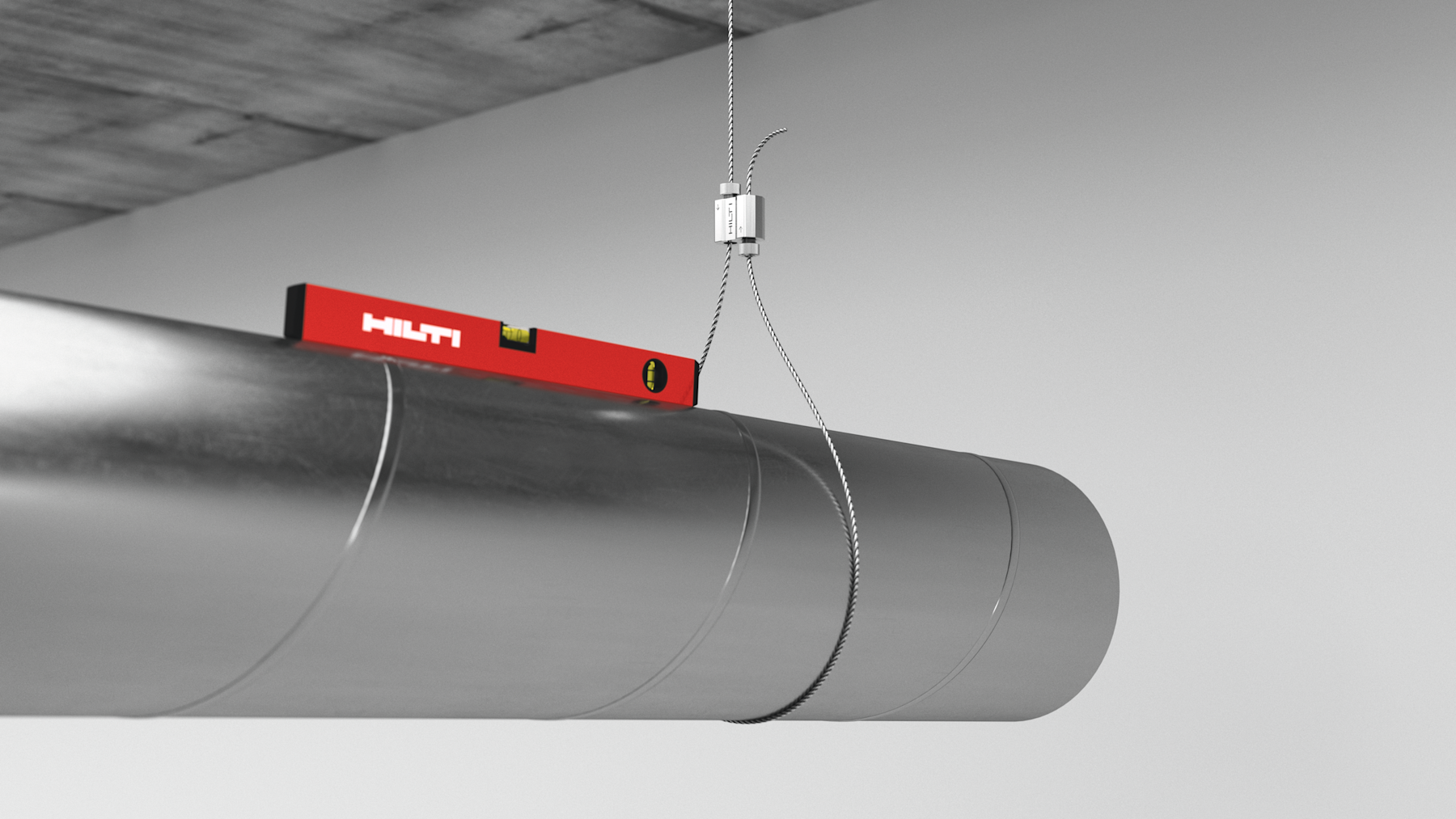 Metal ventilation duct suspended from a concrete ceiling by a cable hanger, with a red Hilti spirit level placed on top to check alignment.