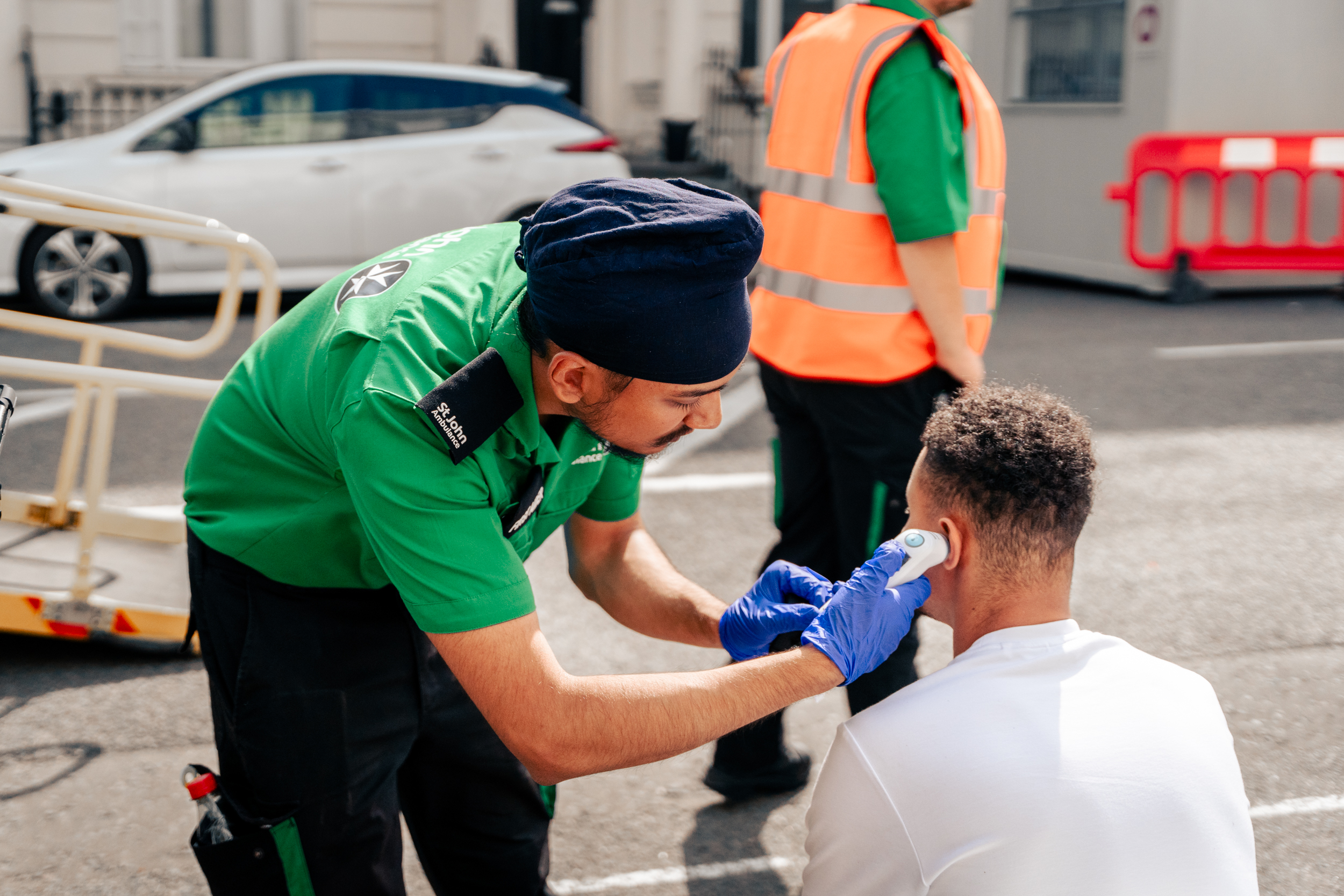A photograph of a St John volunteer attending to a member of the public.