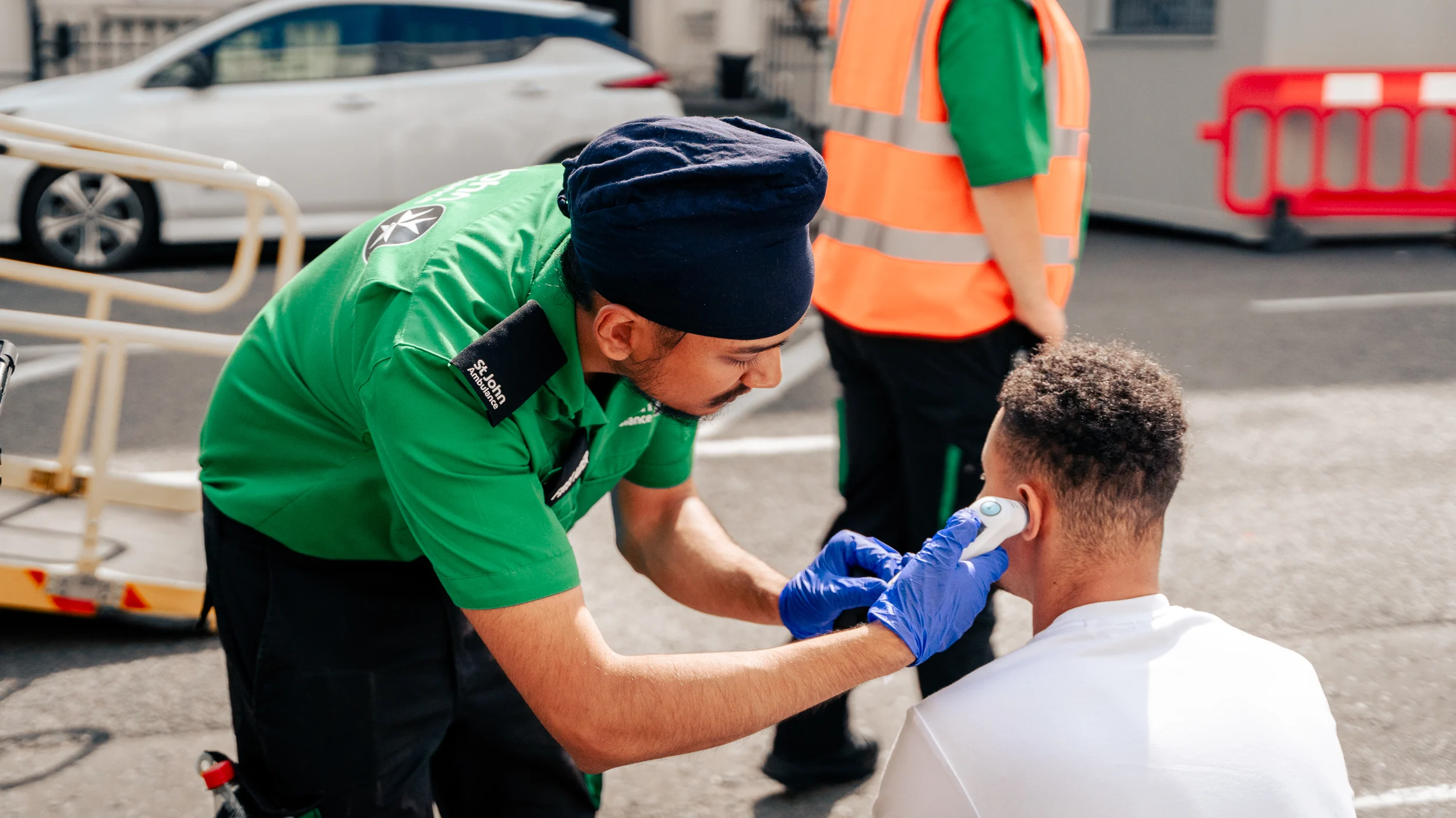 A photograph of a St John volunteer attending to a member of the public.