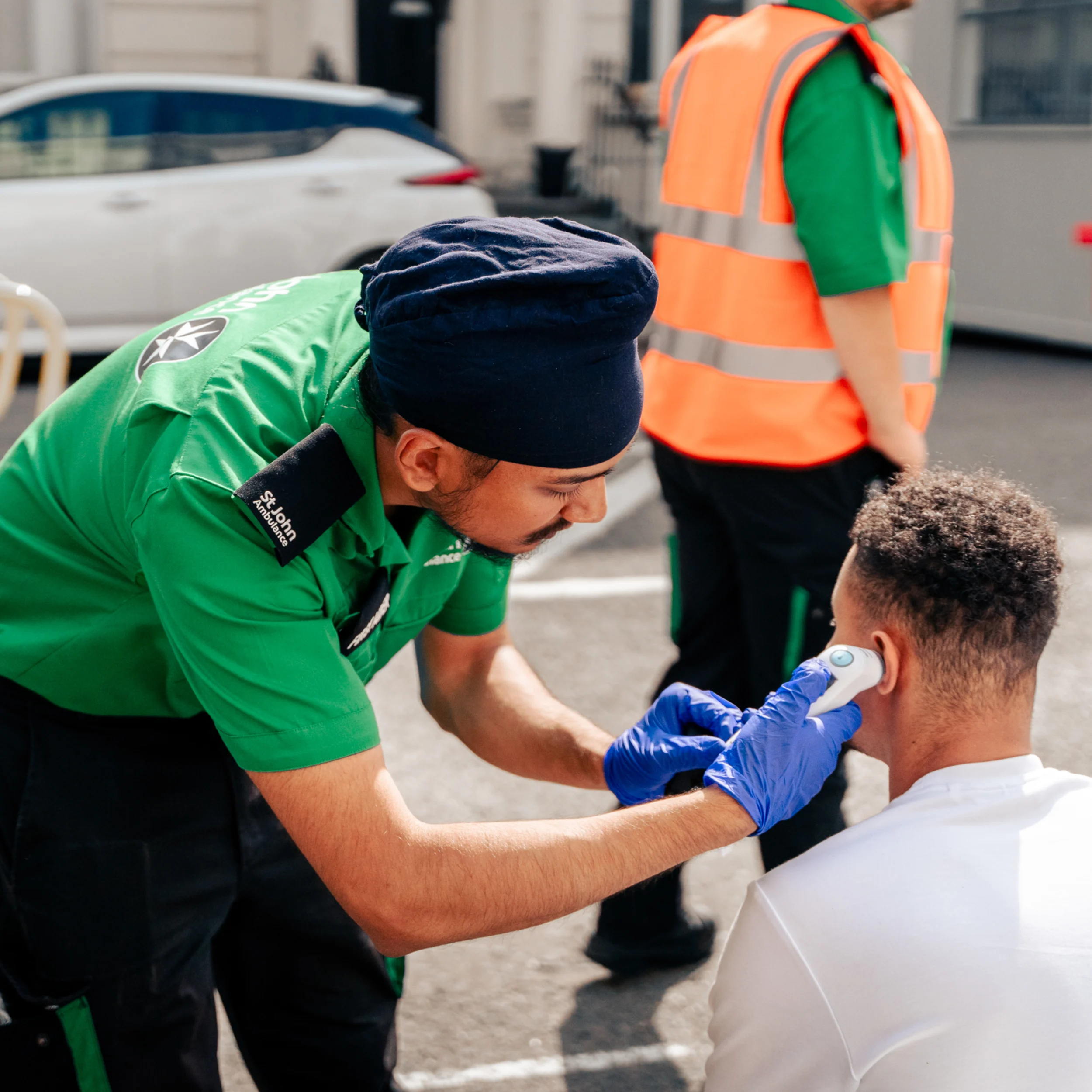 A photograph of a St John volunteer attending to a member of the public.