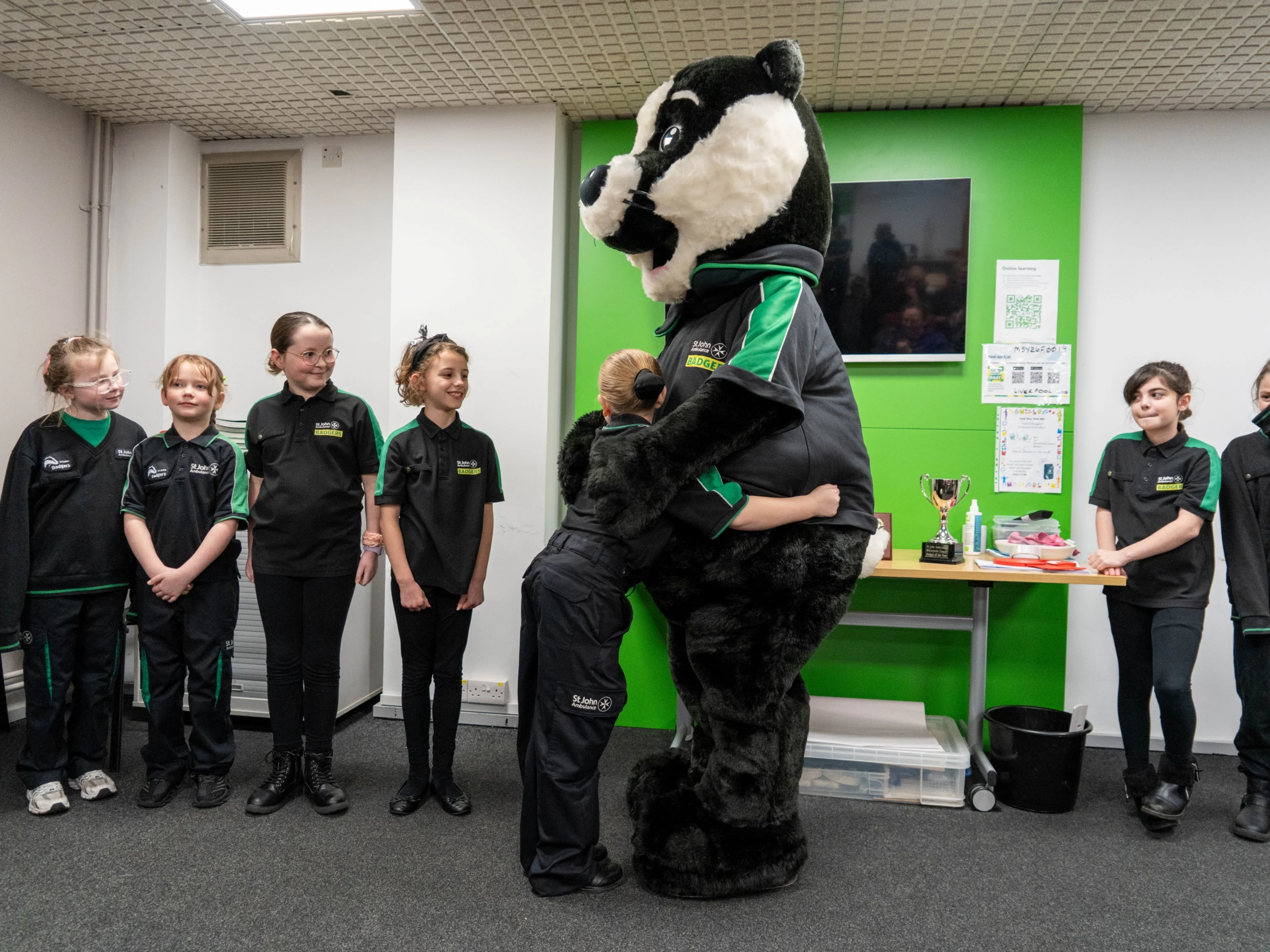 Some St John Ambulance Badgers with mascot Bertie. One of the Badgers is hugging Bertie!