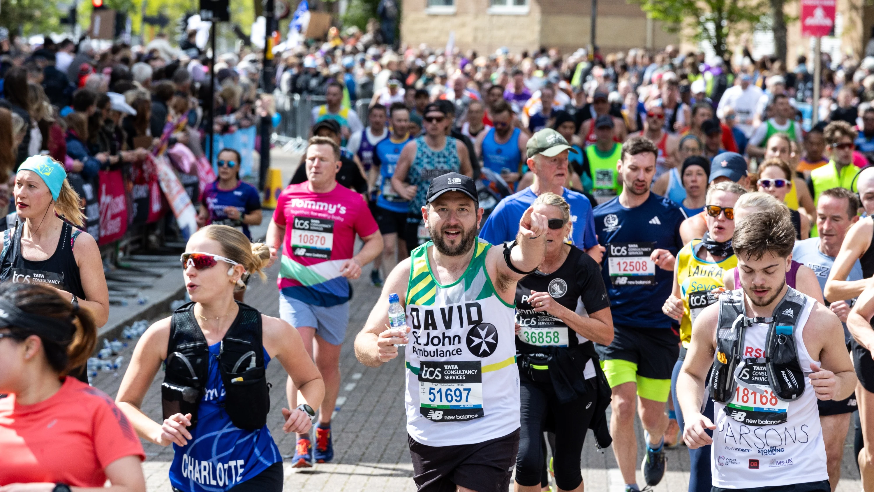 Marathon runners, with one St John Ambulance fundraiser pointing at the photographer.
